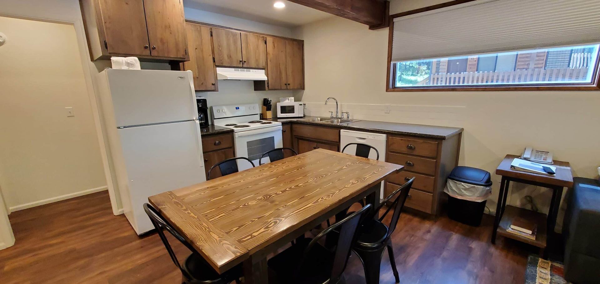 A kitchen with a table and chairs and a refrigerator.