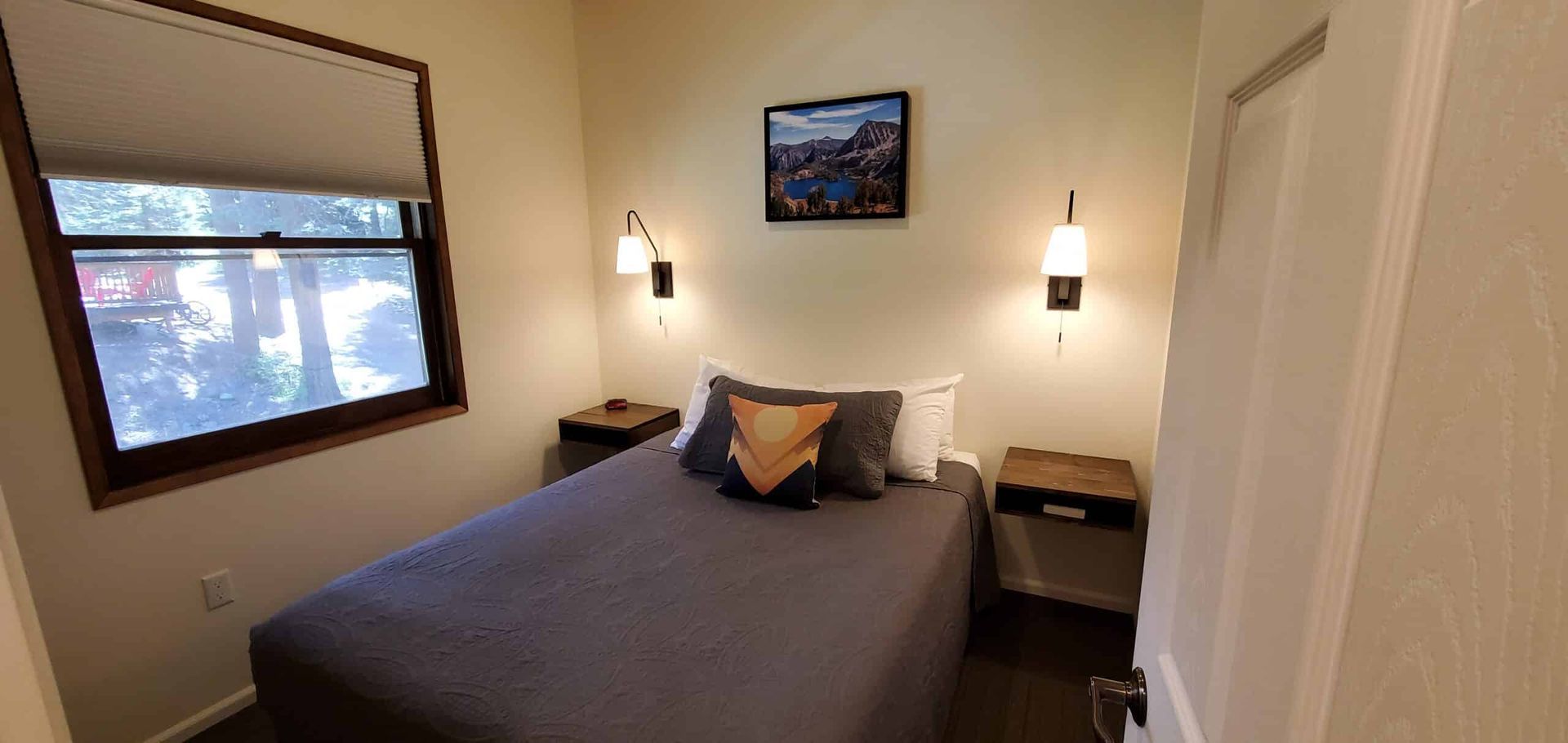 A bedroom with a bed , nightstands , and a window.