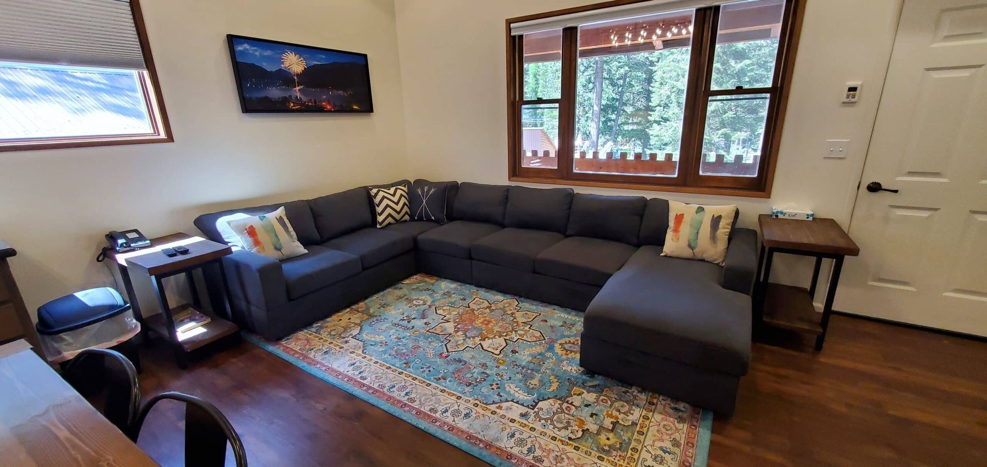 A living room with a large sectional couch and a rug.