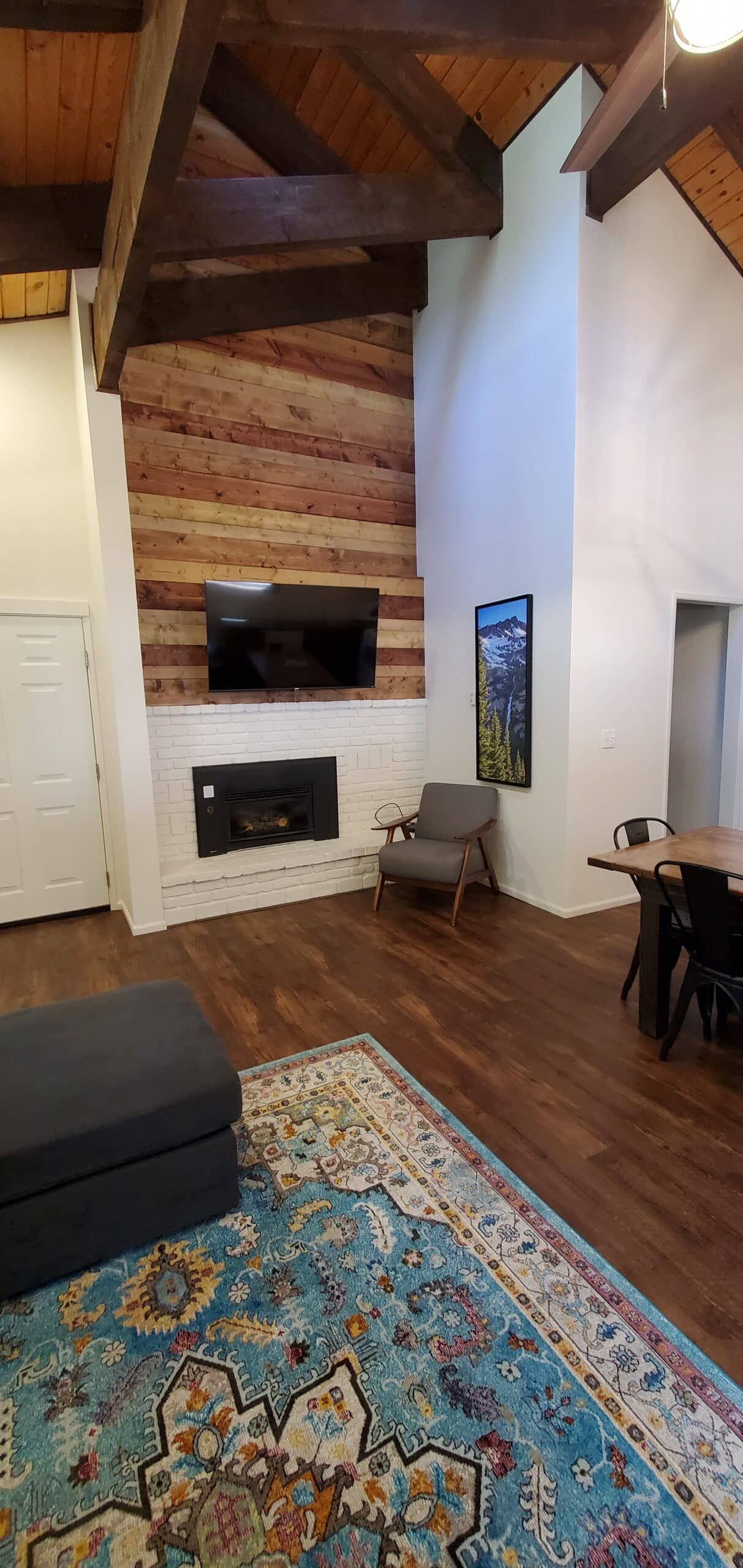 A living room with a fireplace and a rug.