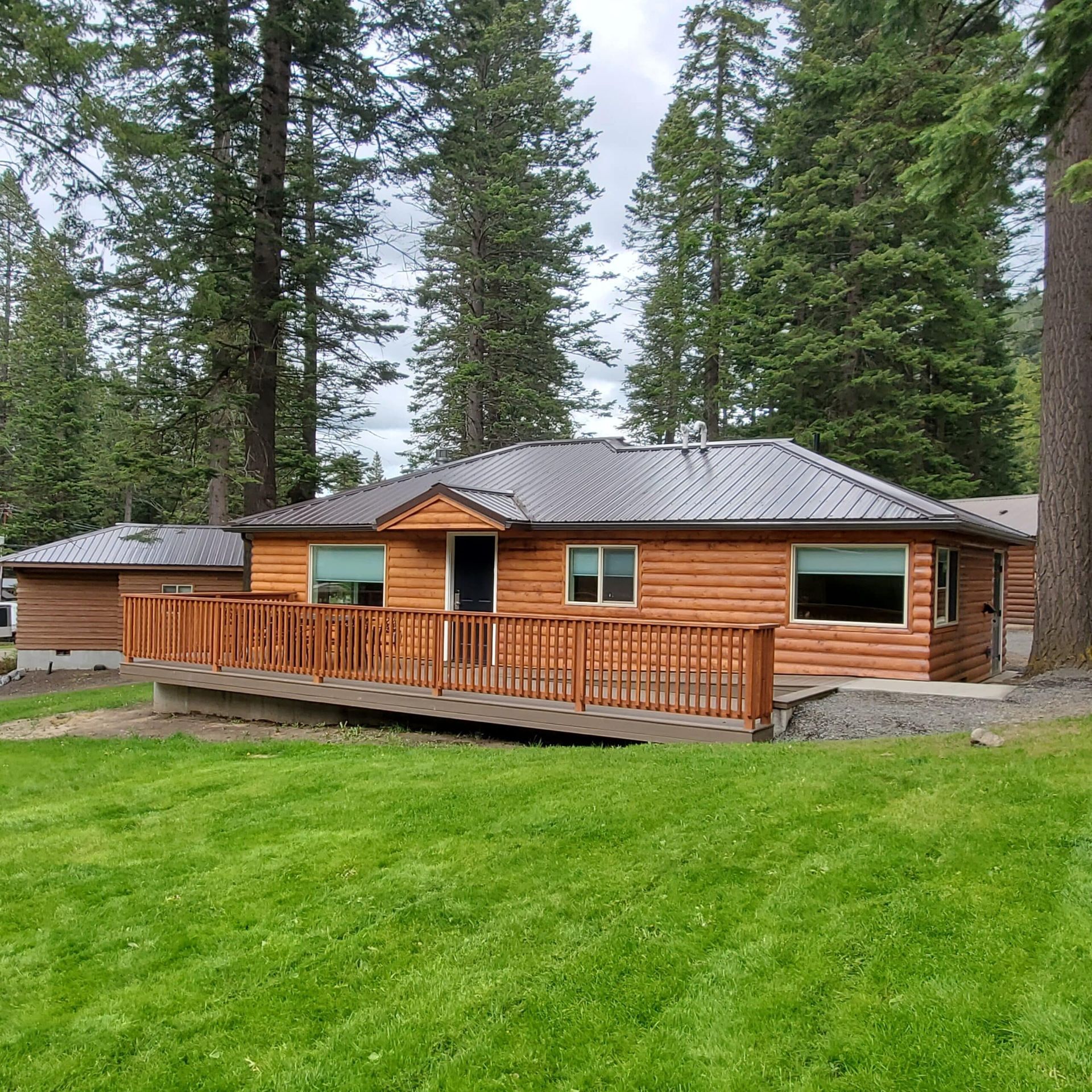 A log cabin with a metal roof and a wooden deck