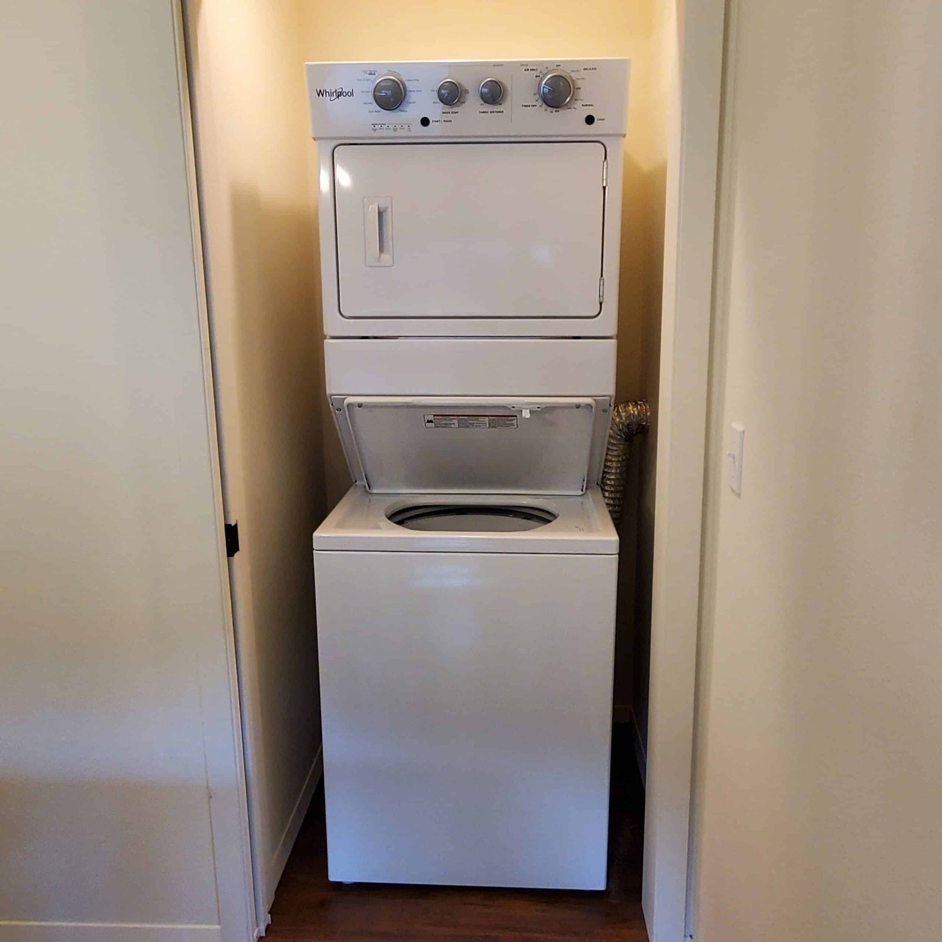 A washer and dryer are stacked on top of each other in a closet.