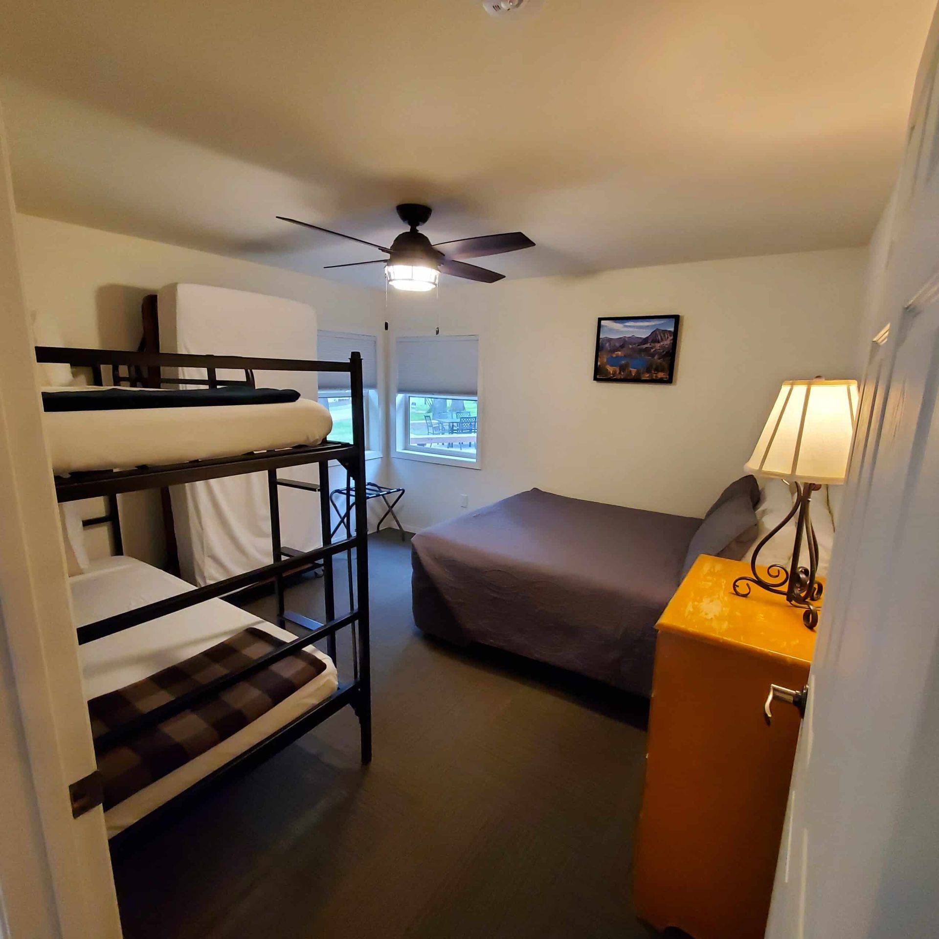 A bedroom with bunk beds and a ceiling fan
