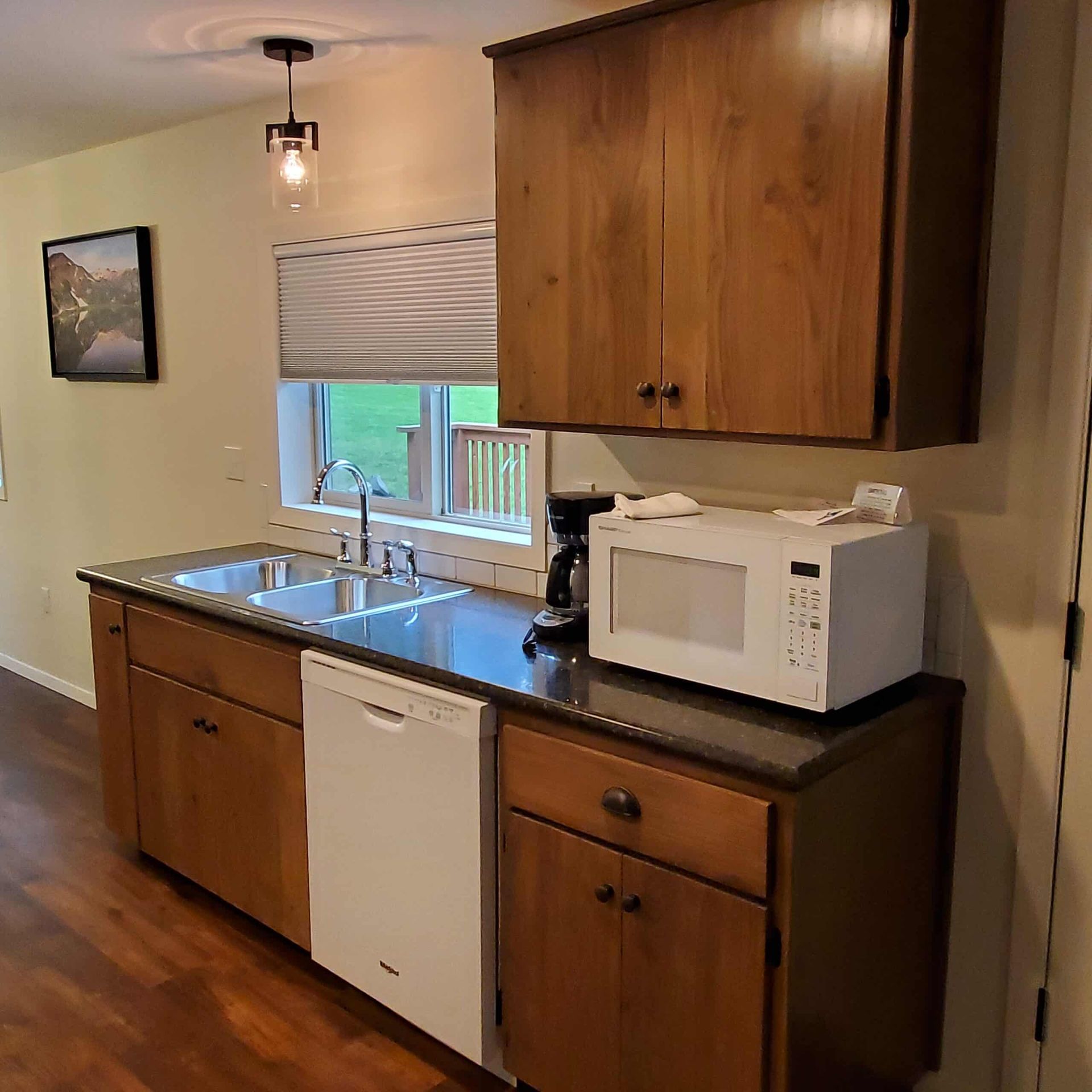 A kitchen with a sink , microwave , and dishwasher