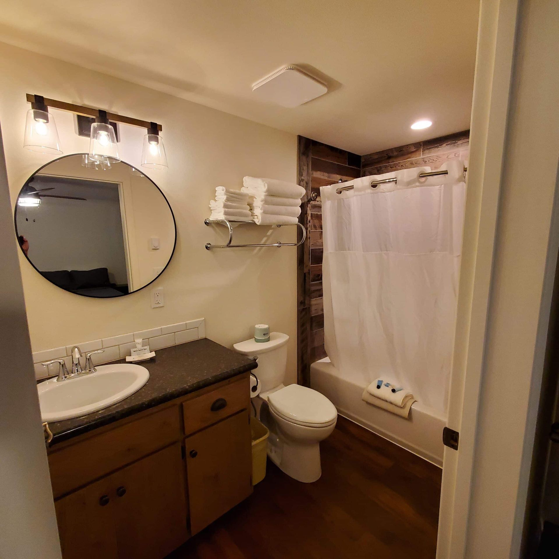 A bathroom with a toilet a sink and a mirror