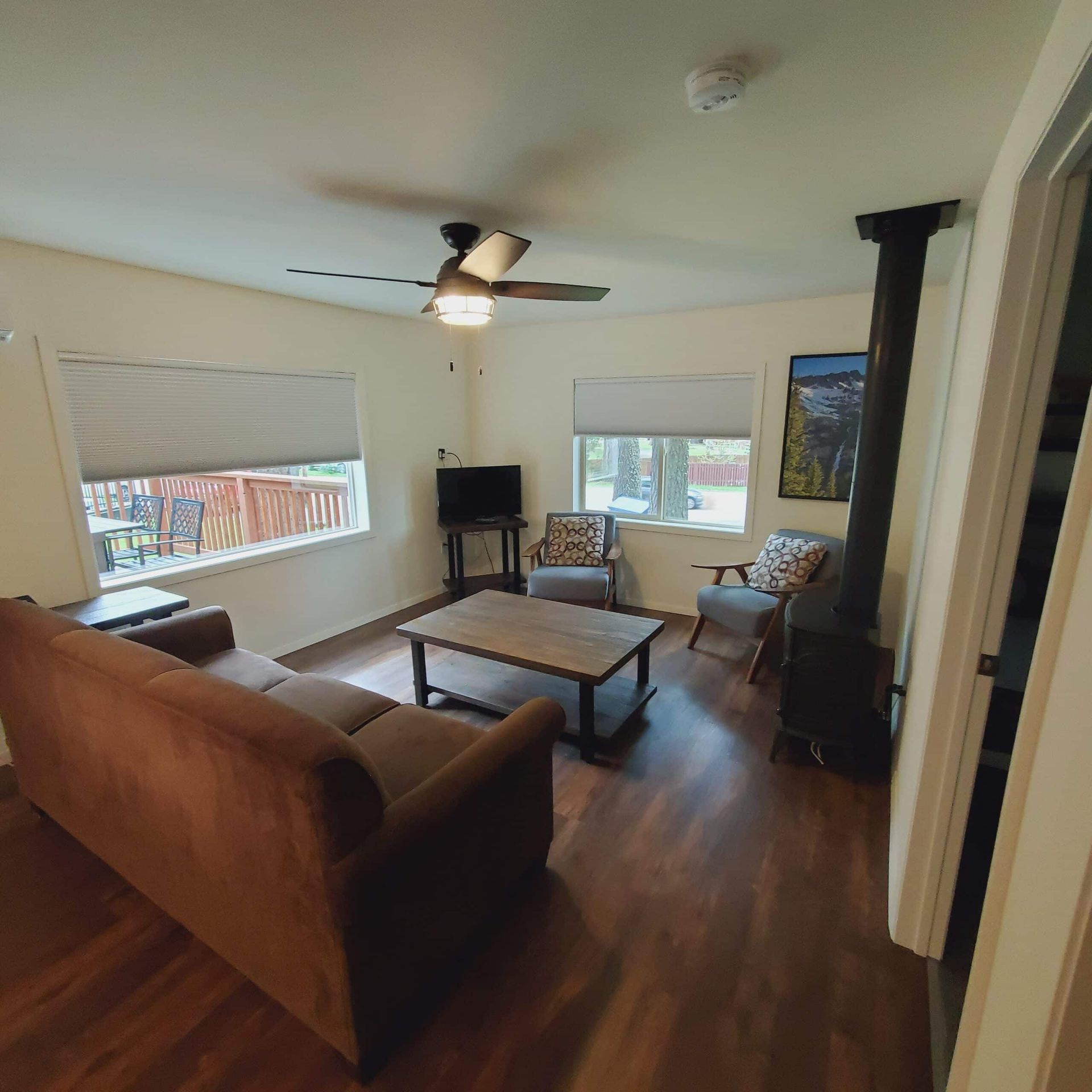 A living room with a couch and chairs and a ceiling fan