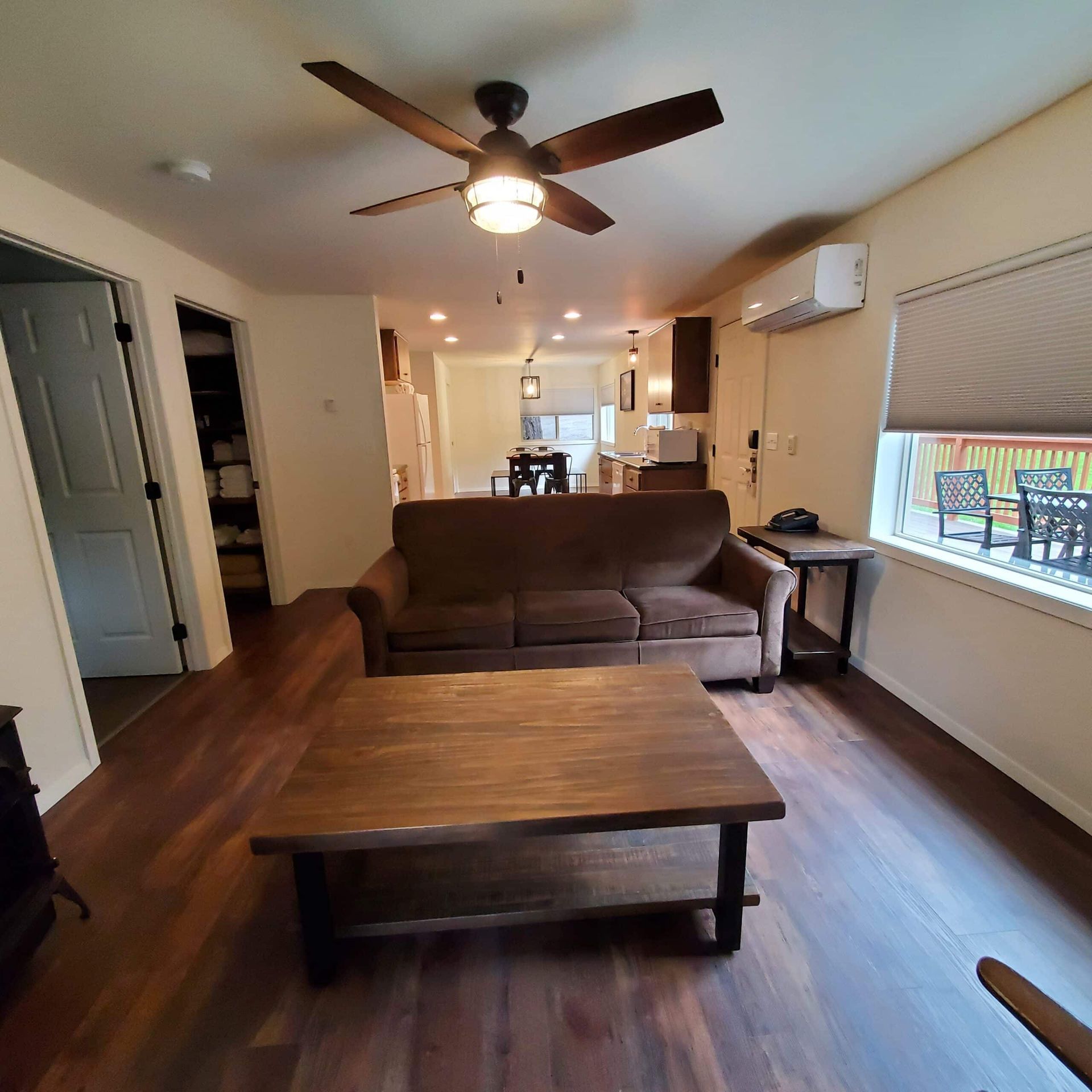 A living room with a couch a coffee table and a ceiling fan
