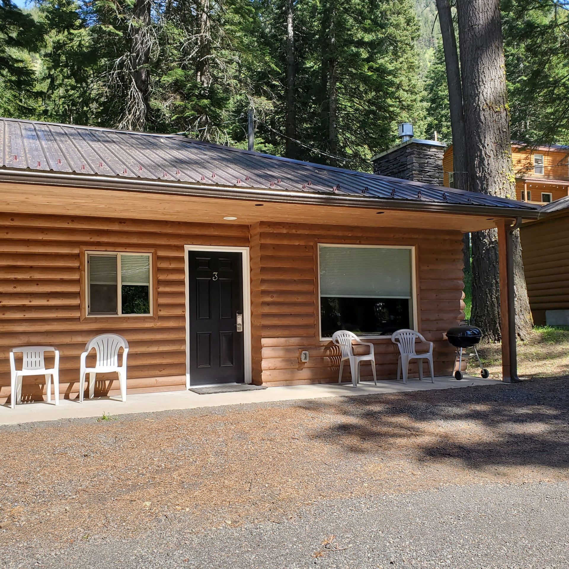 A log cabin with chairs and a table in front of it