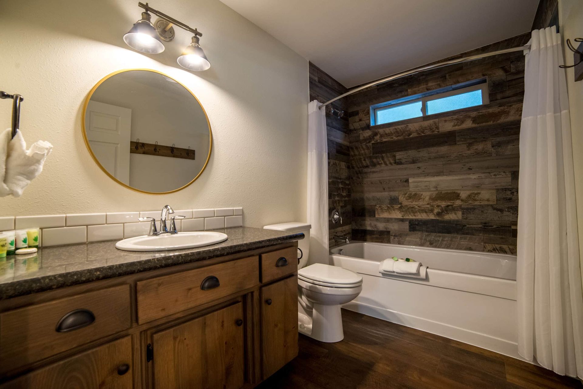 A bathroom with a sink , toilet , tub and mirror.