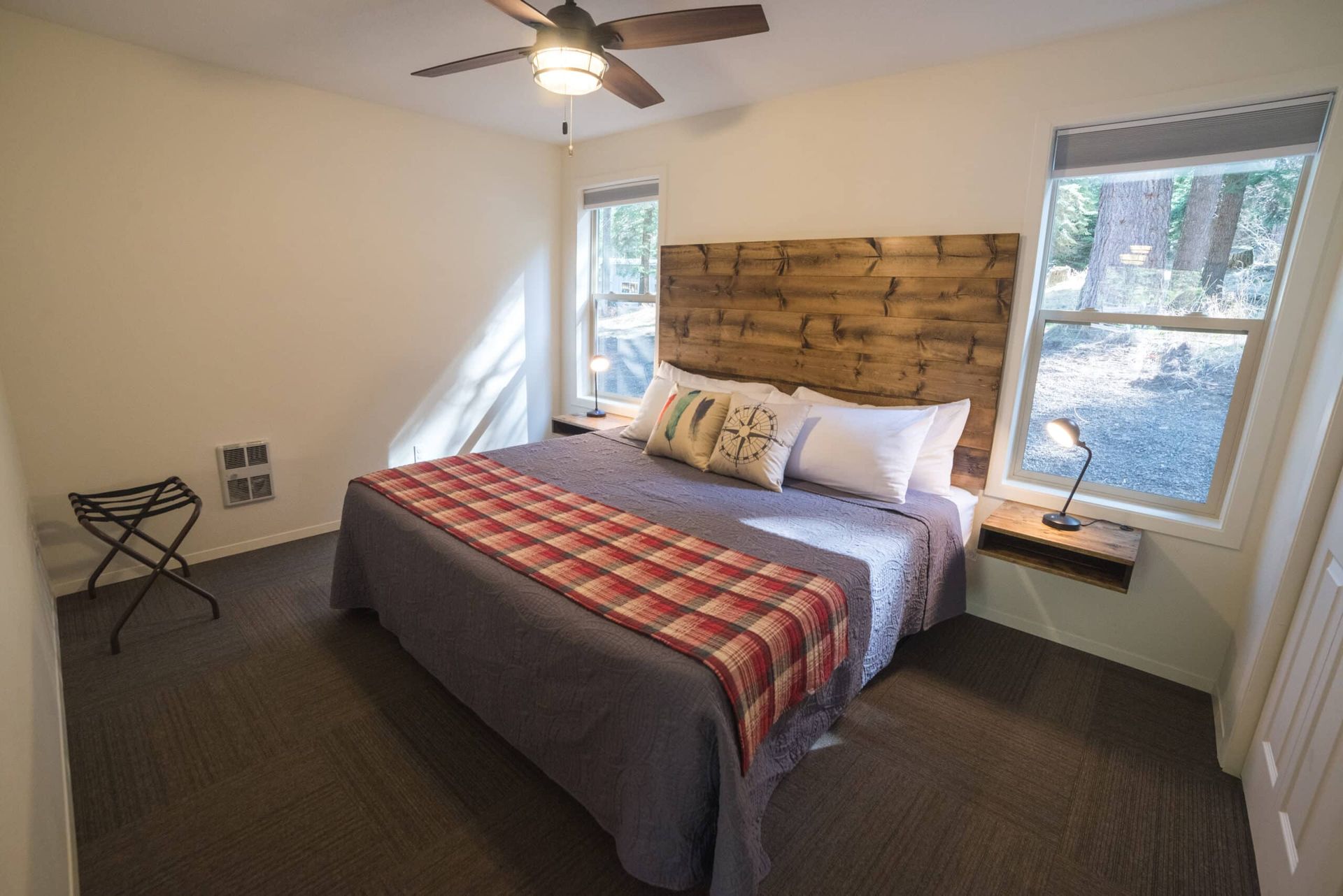 A bedroom with a king size bed and a ceiling fan.