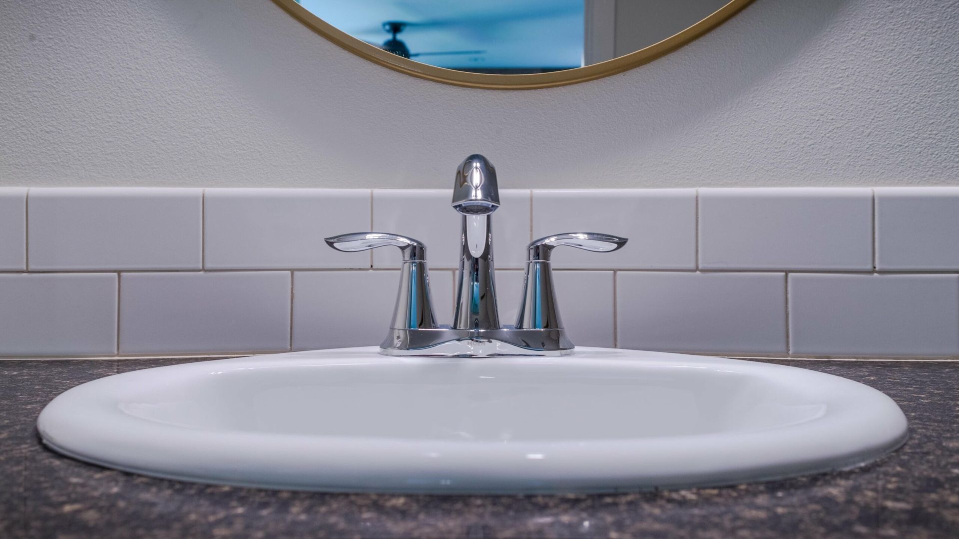 A bathroom sink with a faucet and a mirror.