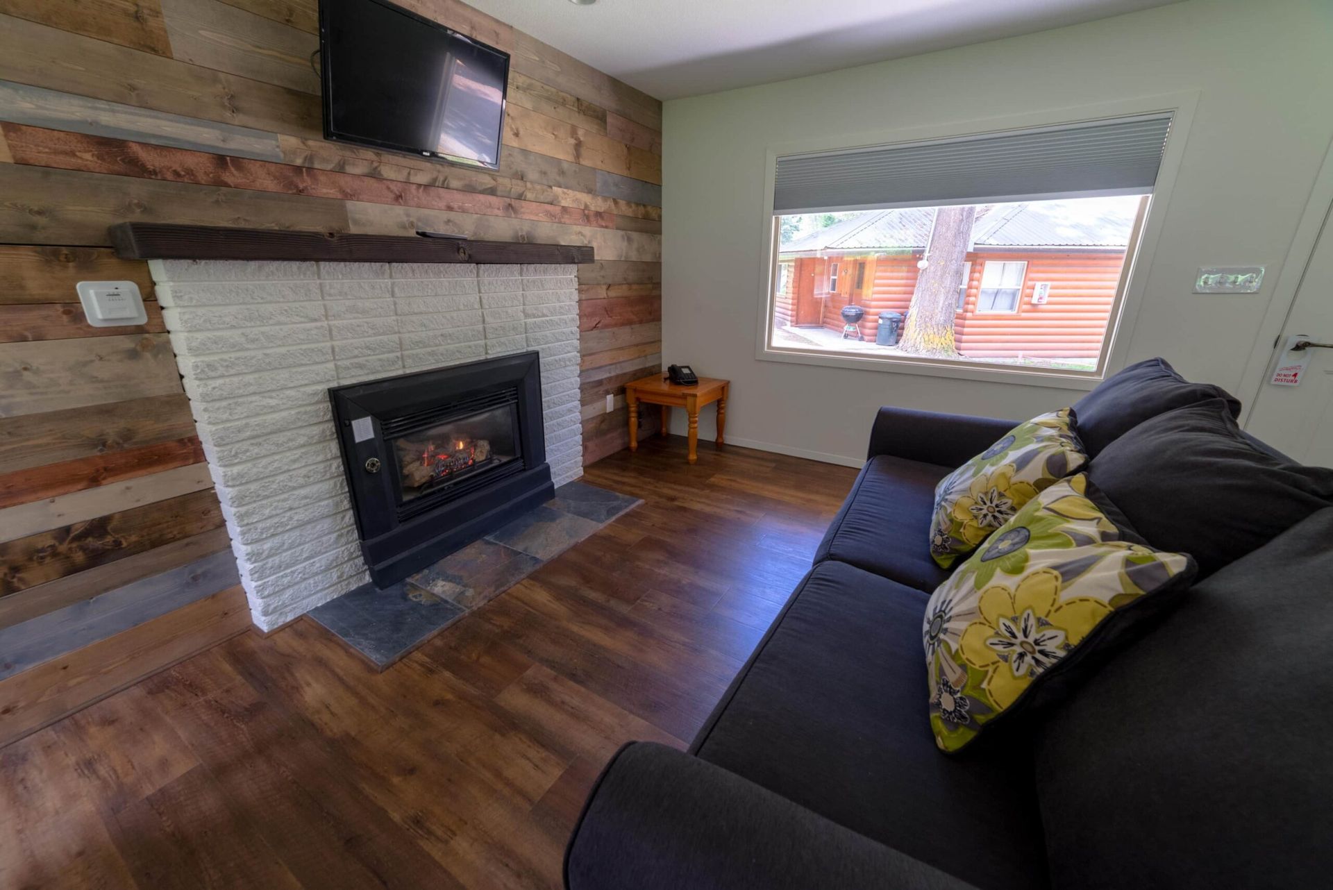 A living room with a couch , fireplace and television.
