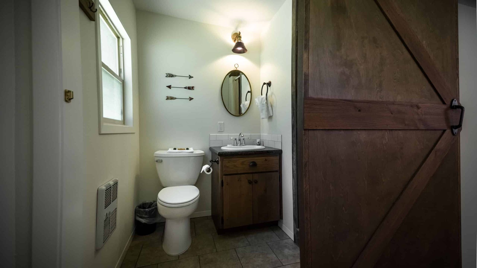 A bathroom with a toilet , sink and mirror.