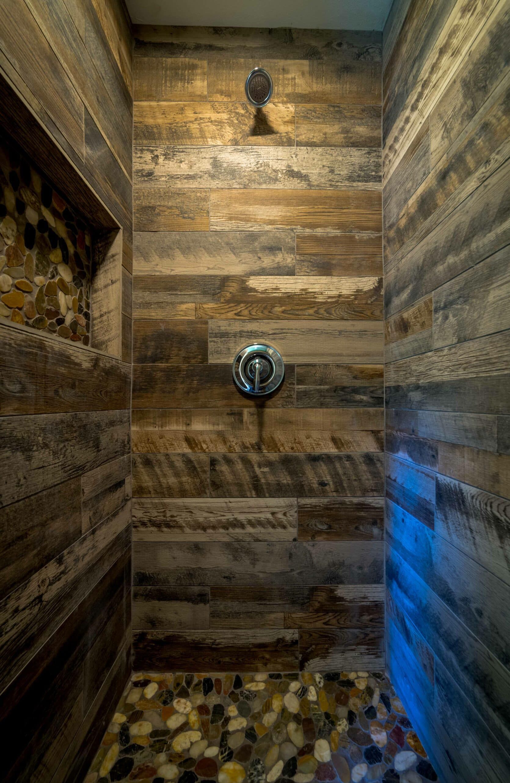 A shower with wooden walls and a tiled floor.