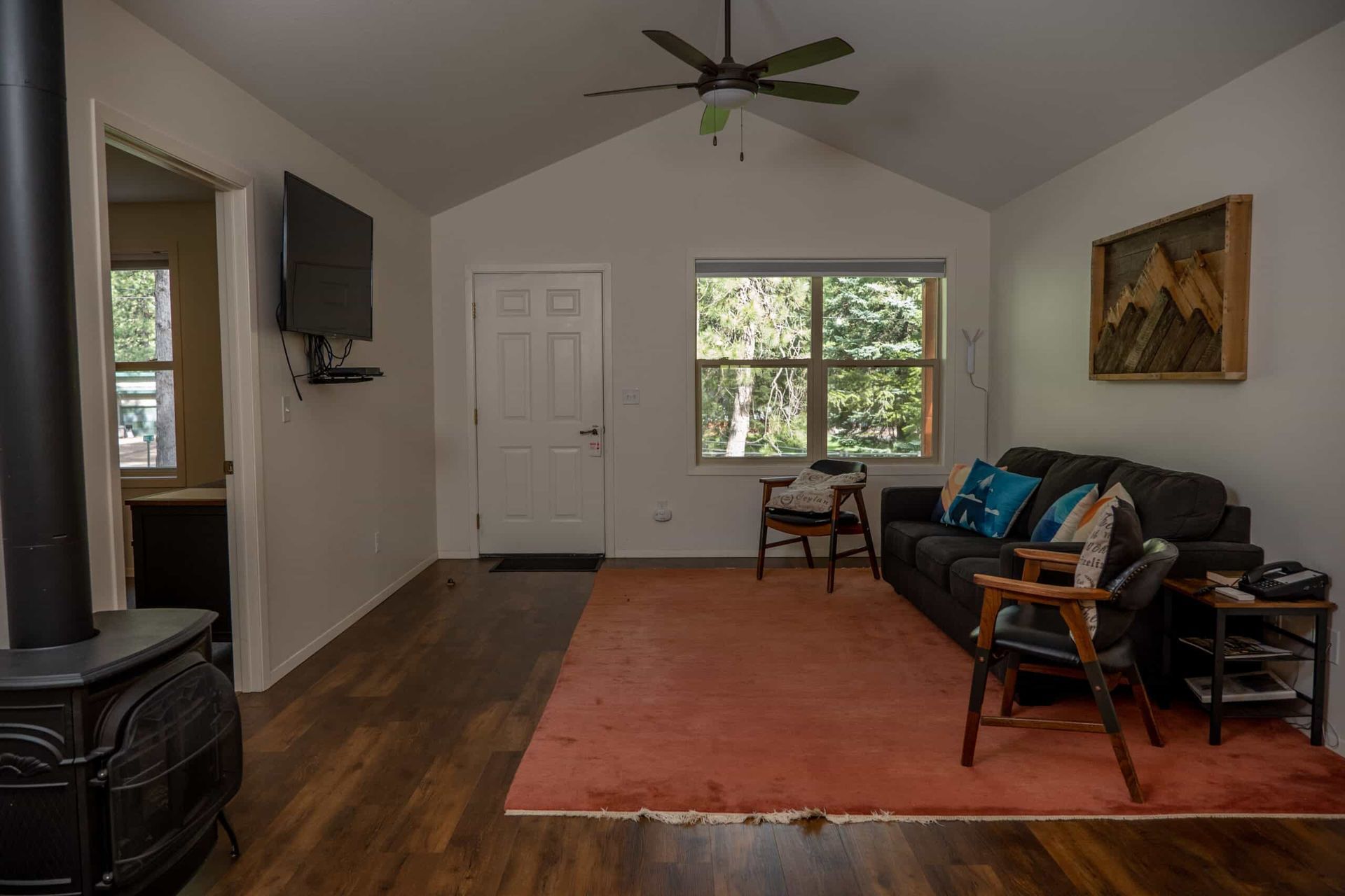 A living room with a couch , chairs , and a television.