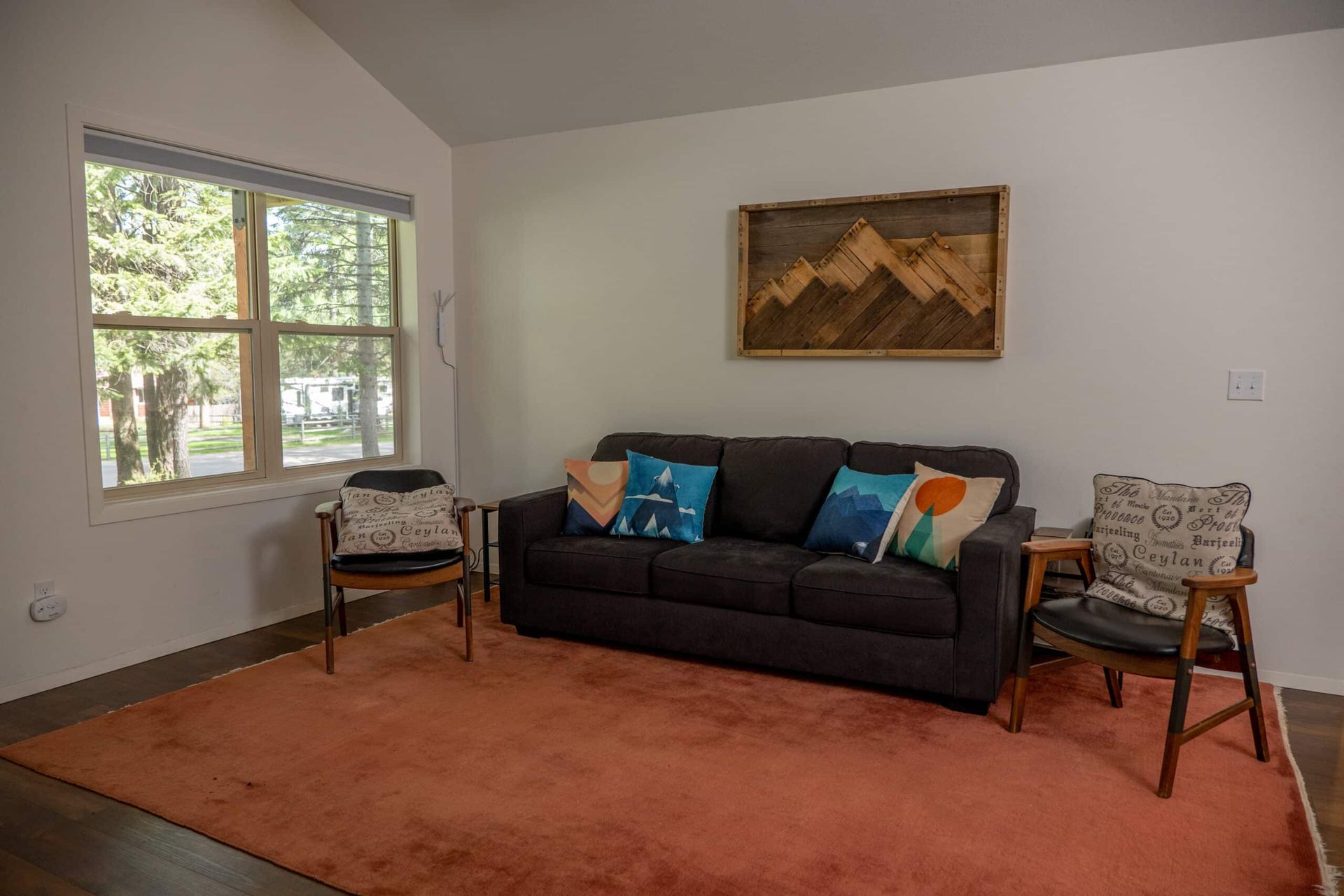 A living room with a couch , chairs , and a rug.