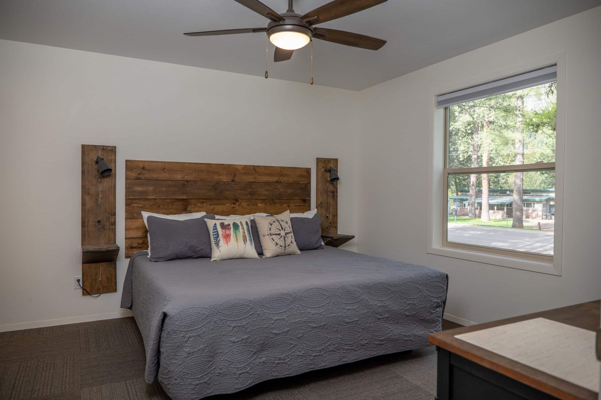 A bedroom with a king size bed and a ceiling fan.
