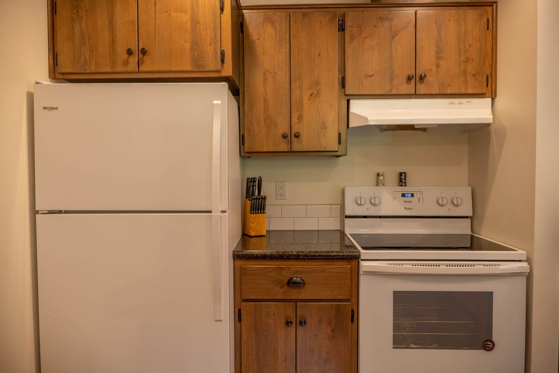 A kitchen with a stove , refrigerator , and cabinets.