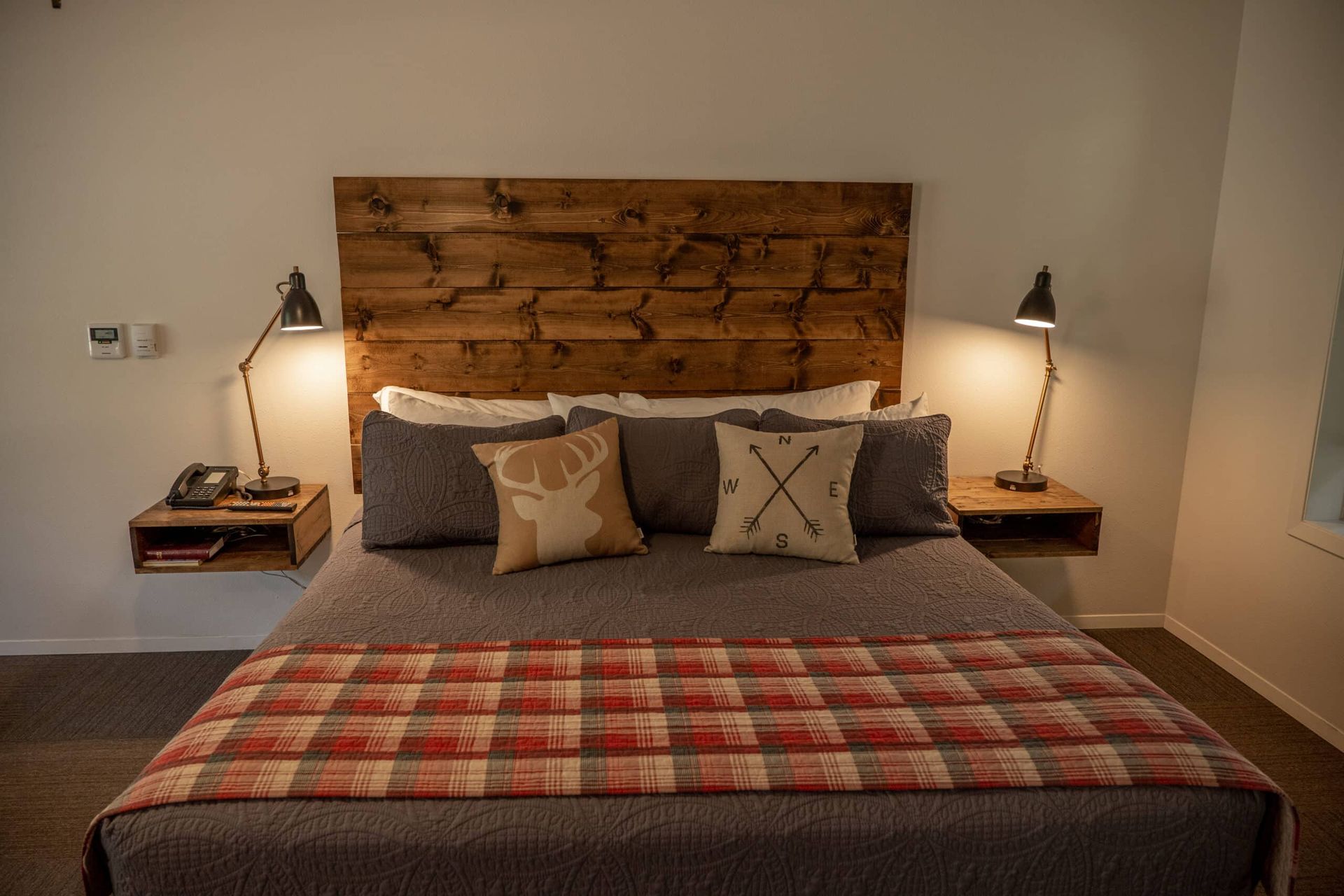 A bed with a wooden headboard and pillows in a bedroom.