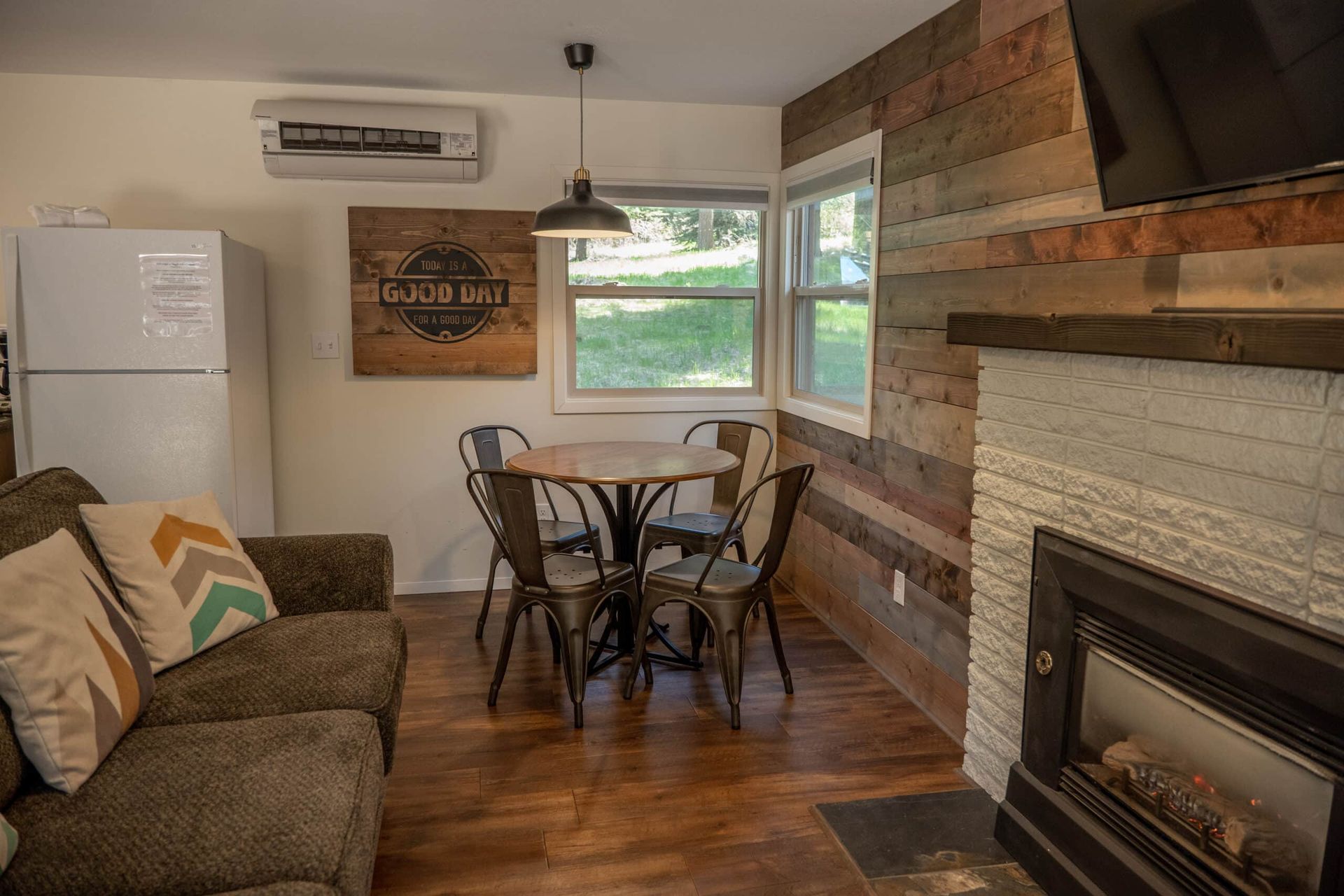 A living room with a couch , table and chairs and a fireplace.
