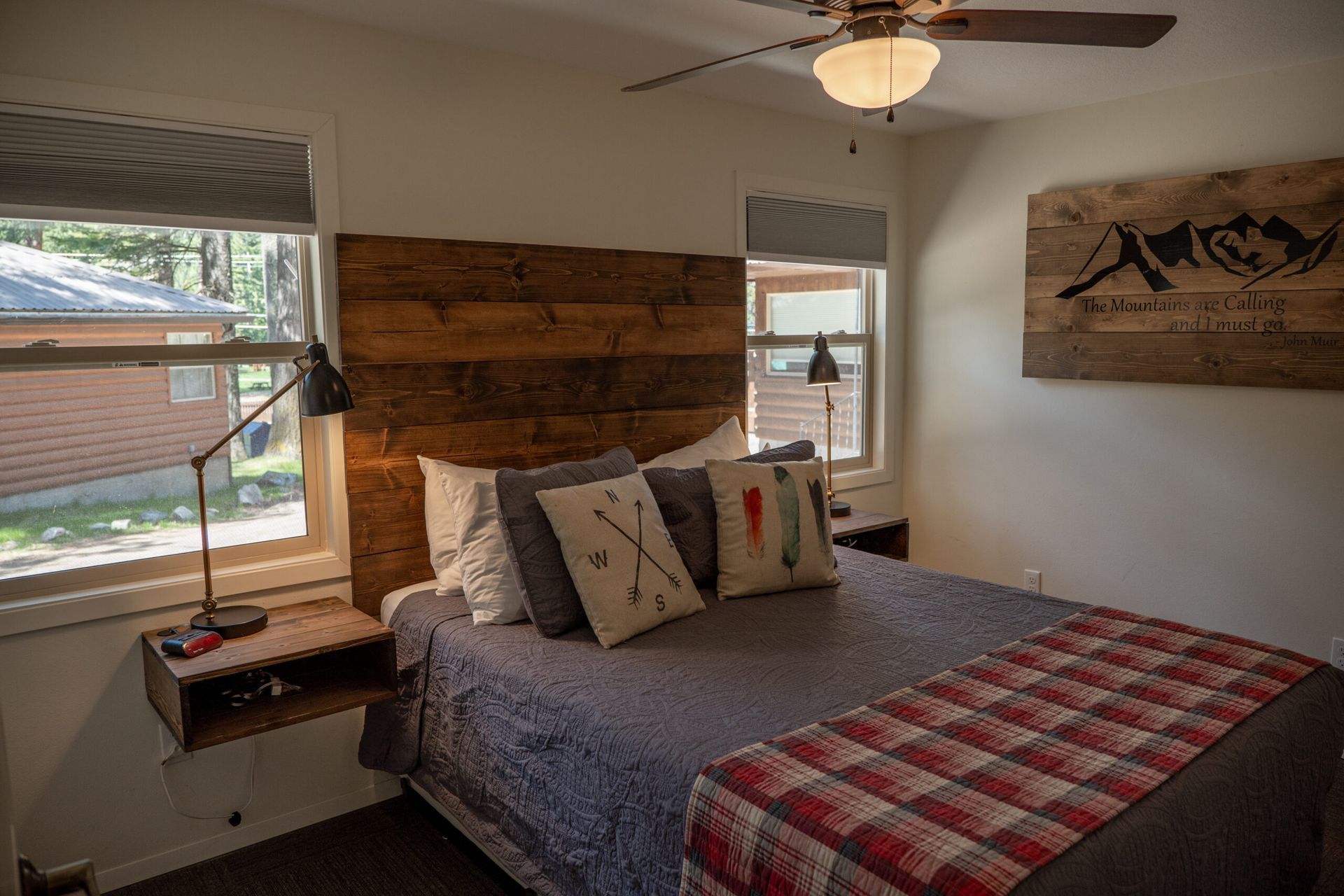 A bedroom with a bed and a ceiling fan.