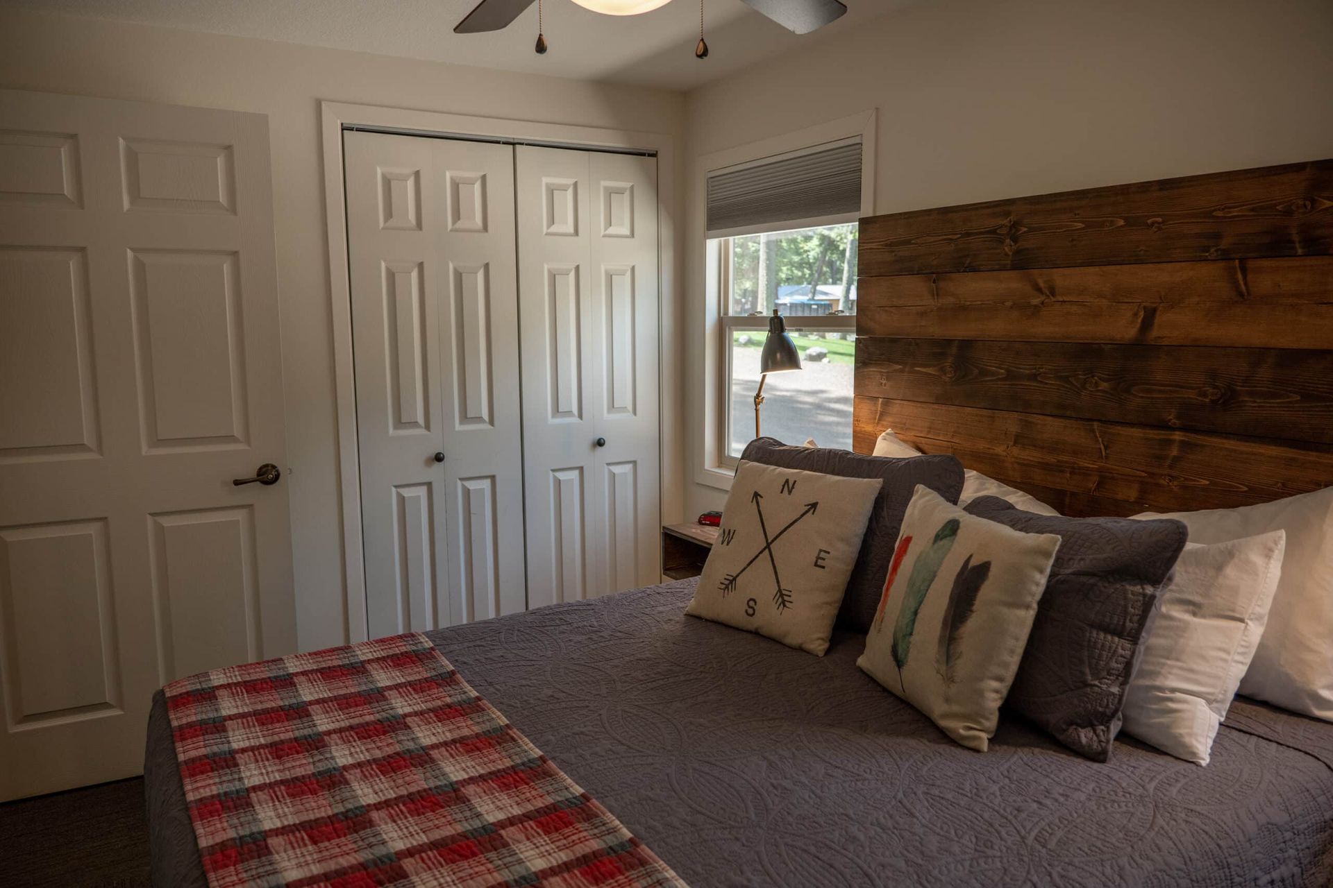 A bedroom with a bed and a wooden headboard.