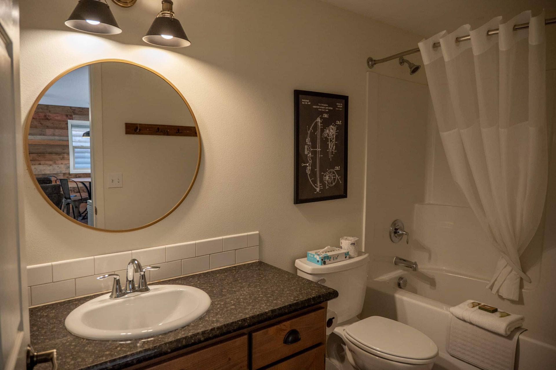 A bathroom with a sink , toilet , tub and mirror.