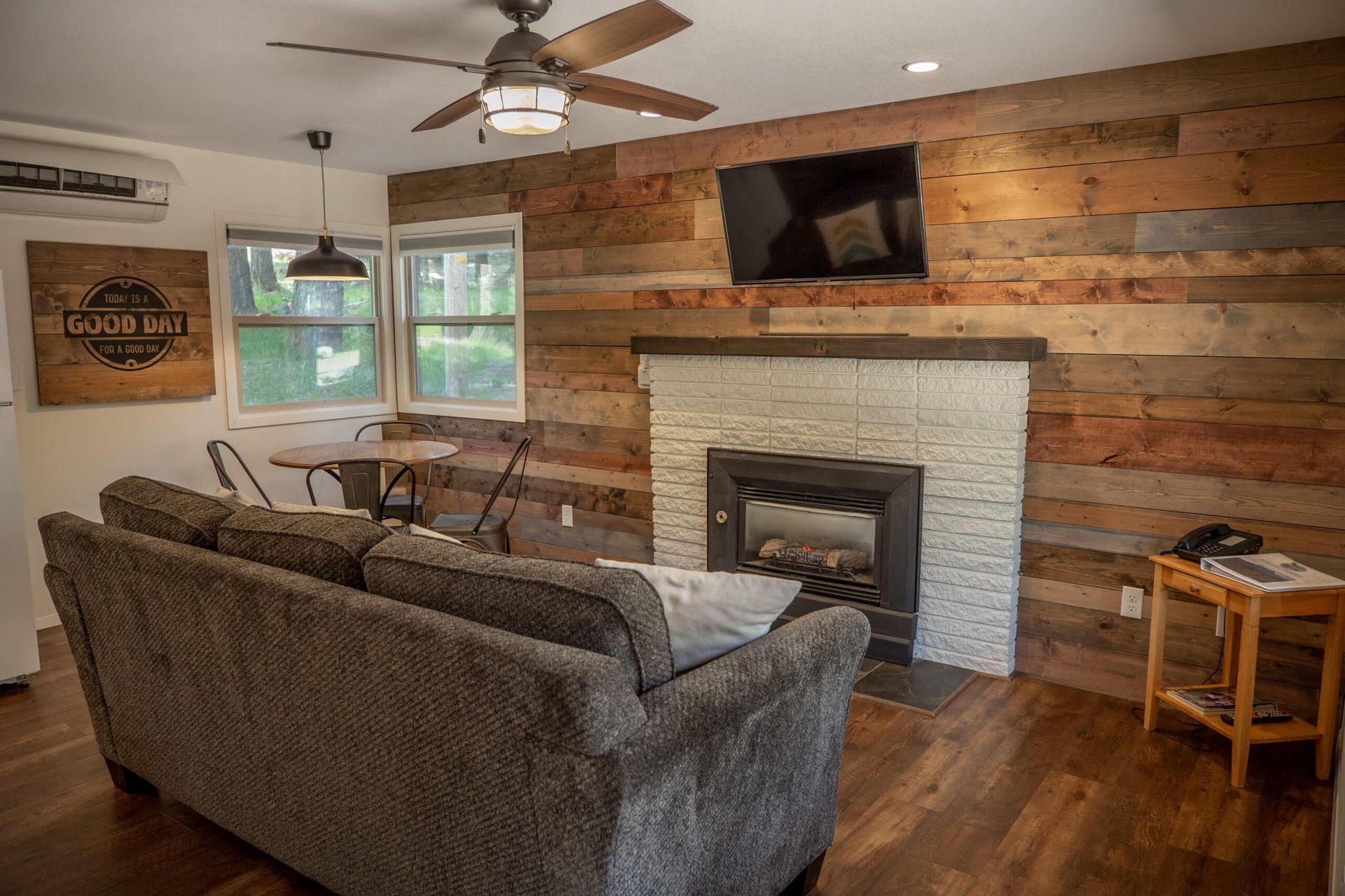 A living room with a couch , fireplace and television.