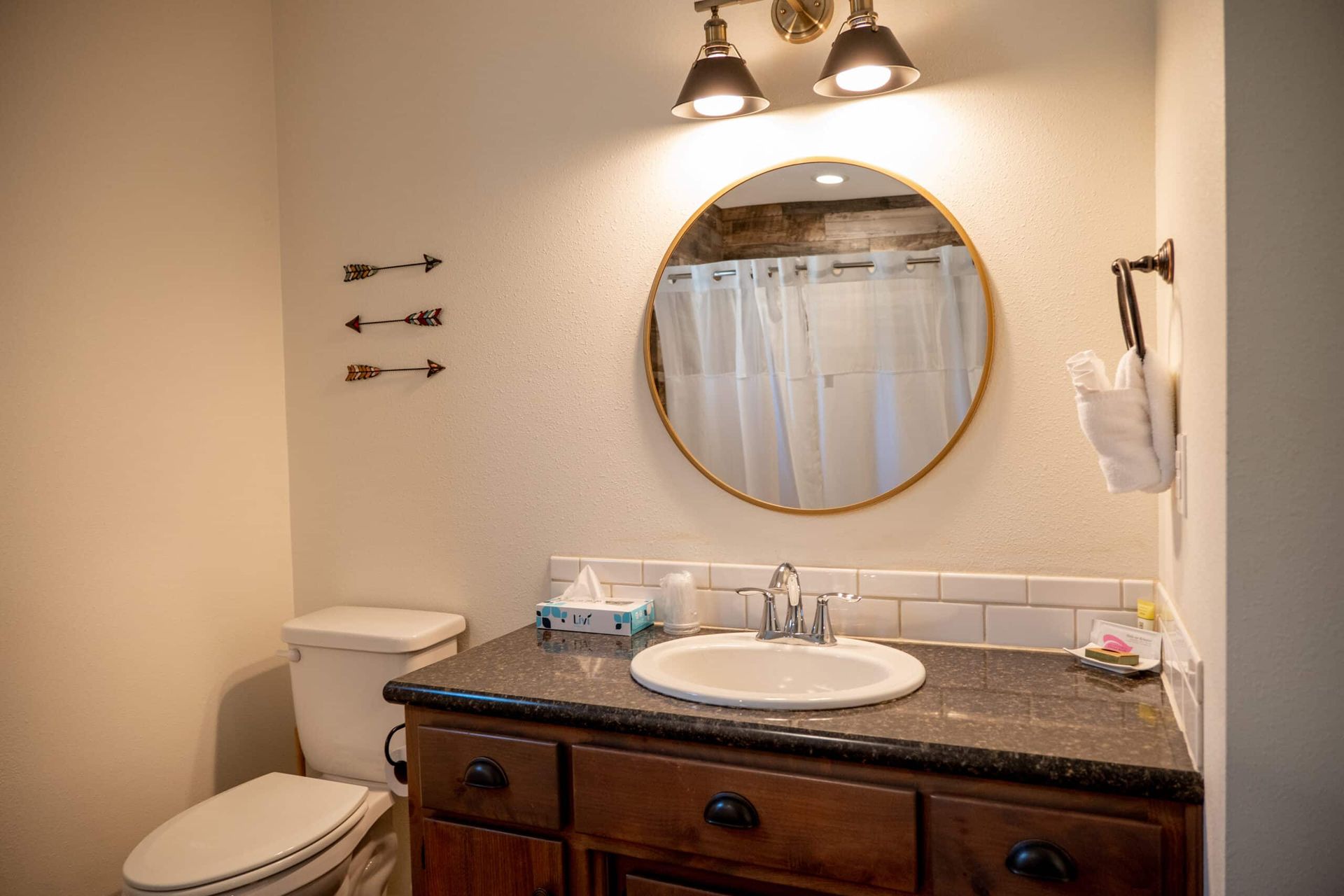 A bathroom with a toilet , sink , and mirror.