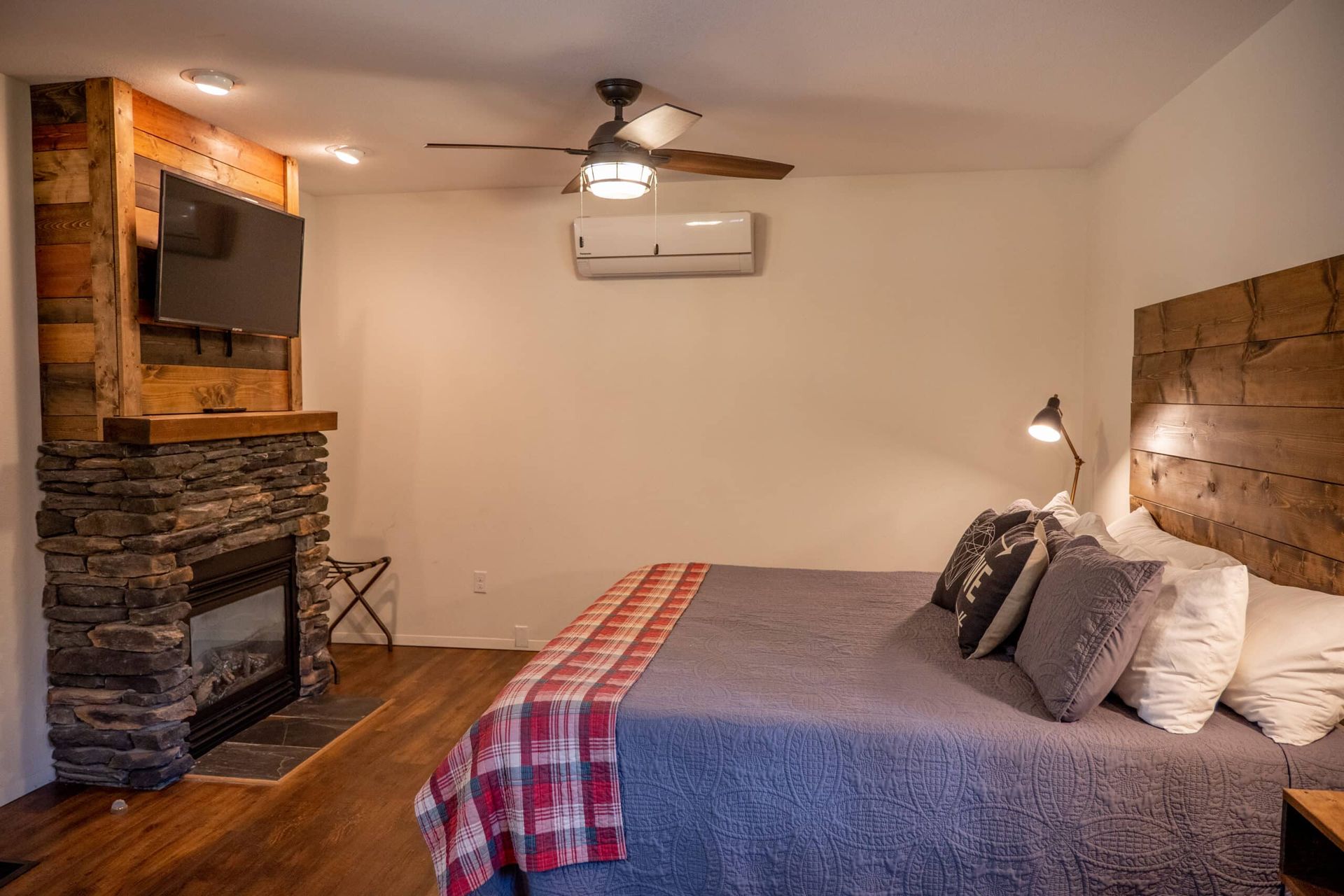 A bedroom with a king size bed , fireplace and television.