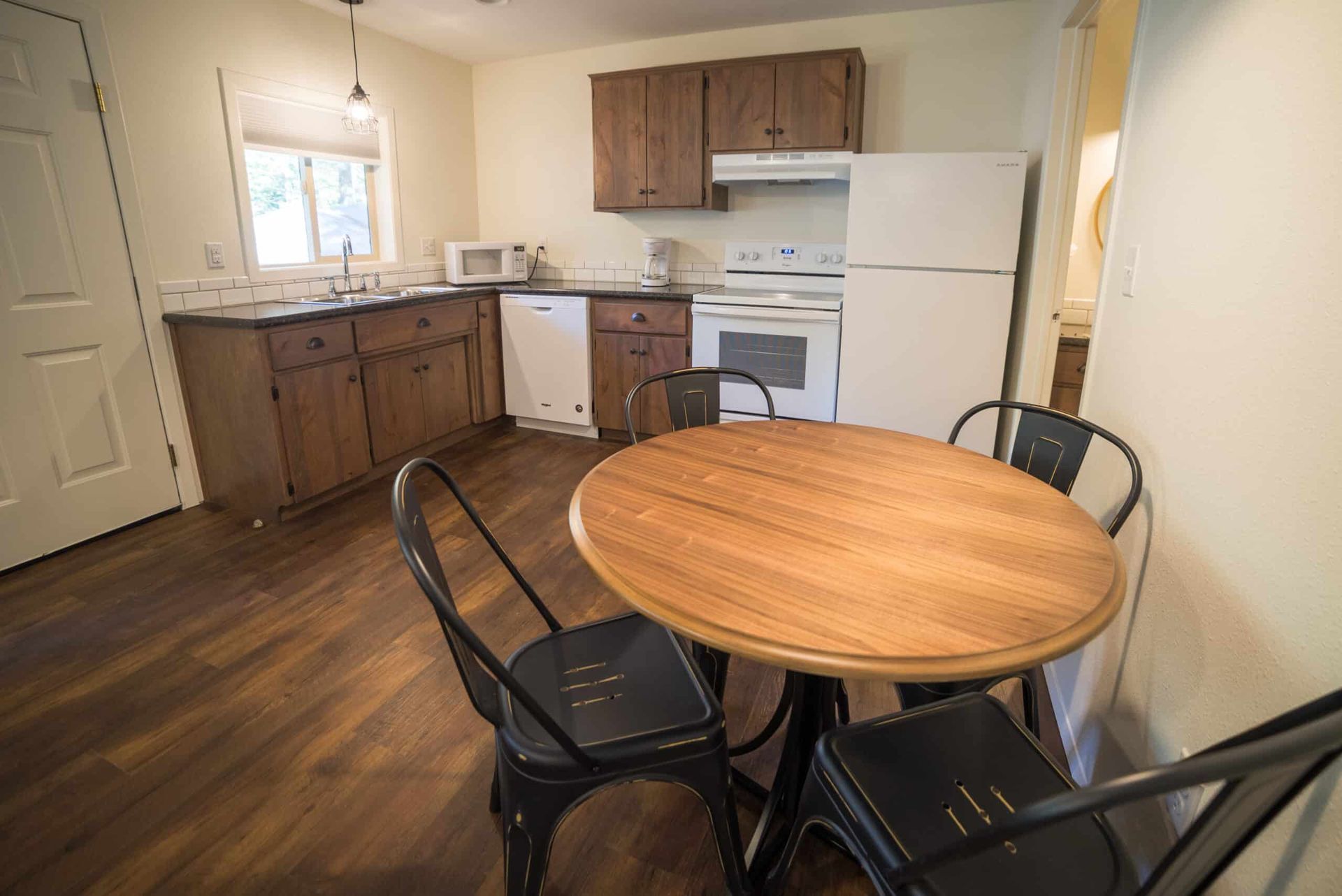 A kitchen with a table and chairs and a refrigerator.
