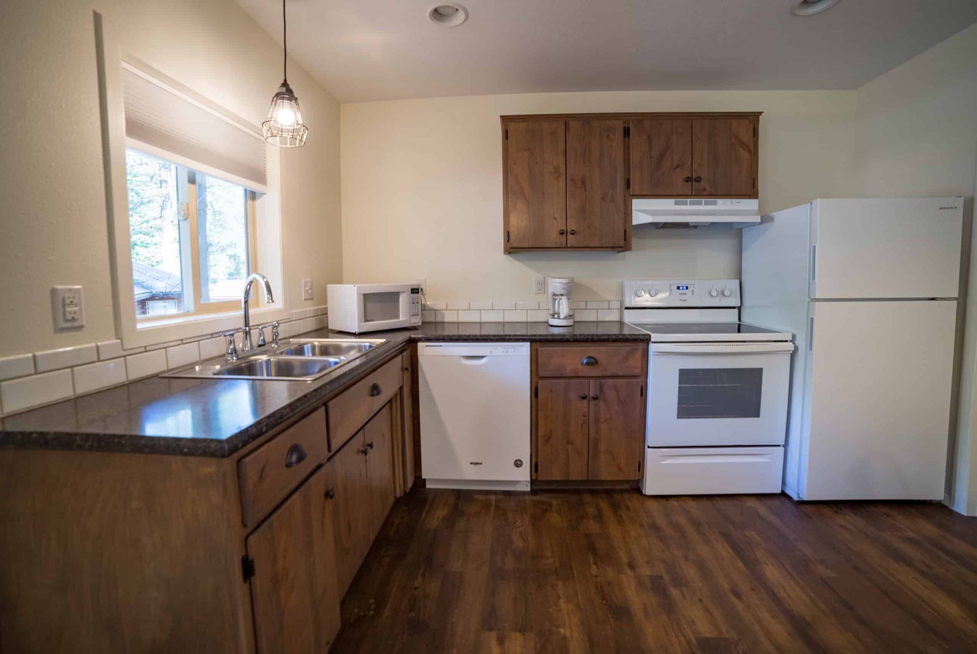 A kitchen with a stove , refrigerator , dishwasher , sink and microwave.