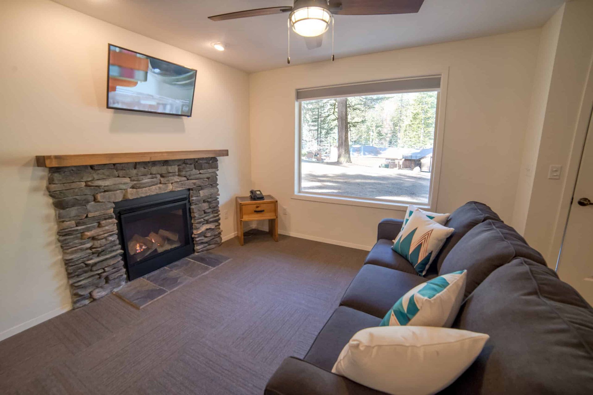 A living room with a couch , fireplace and television.