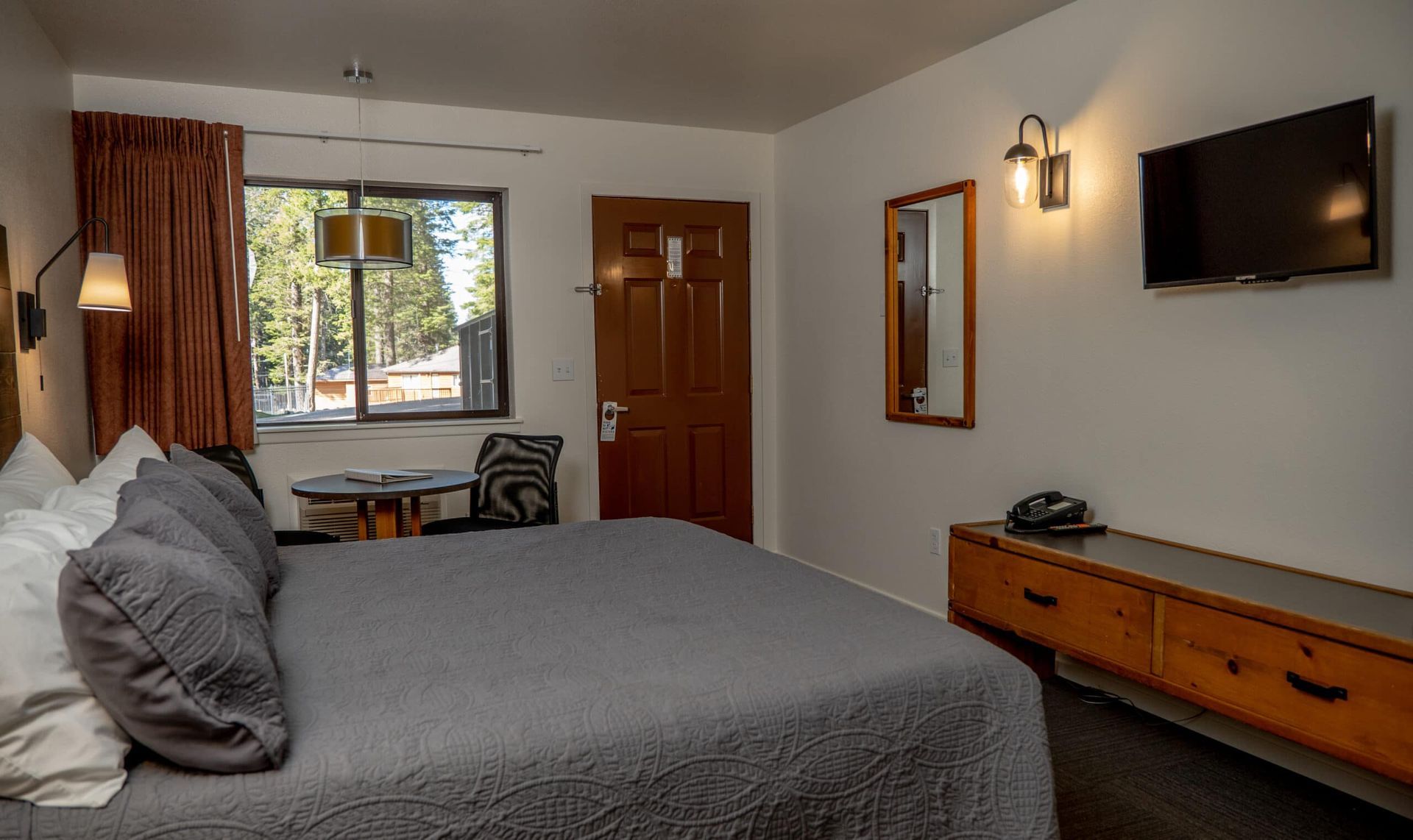 A hotel room with a king size bed and a flat screen tv.