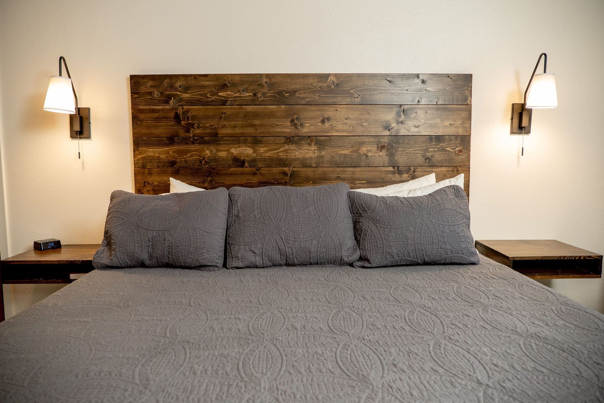 A bed with a wooden headboard and two nightstands in a bedroom.