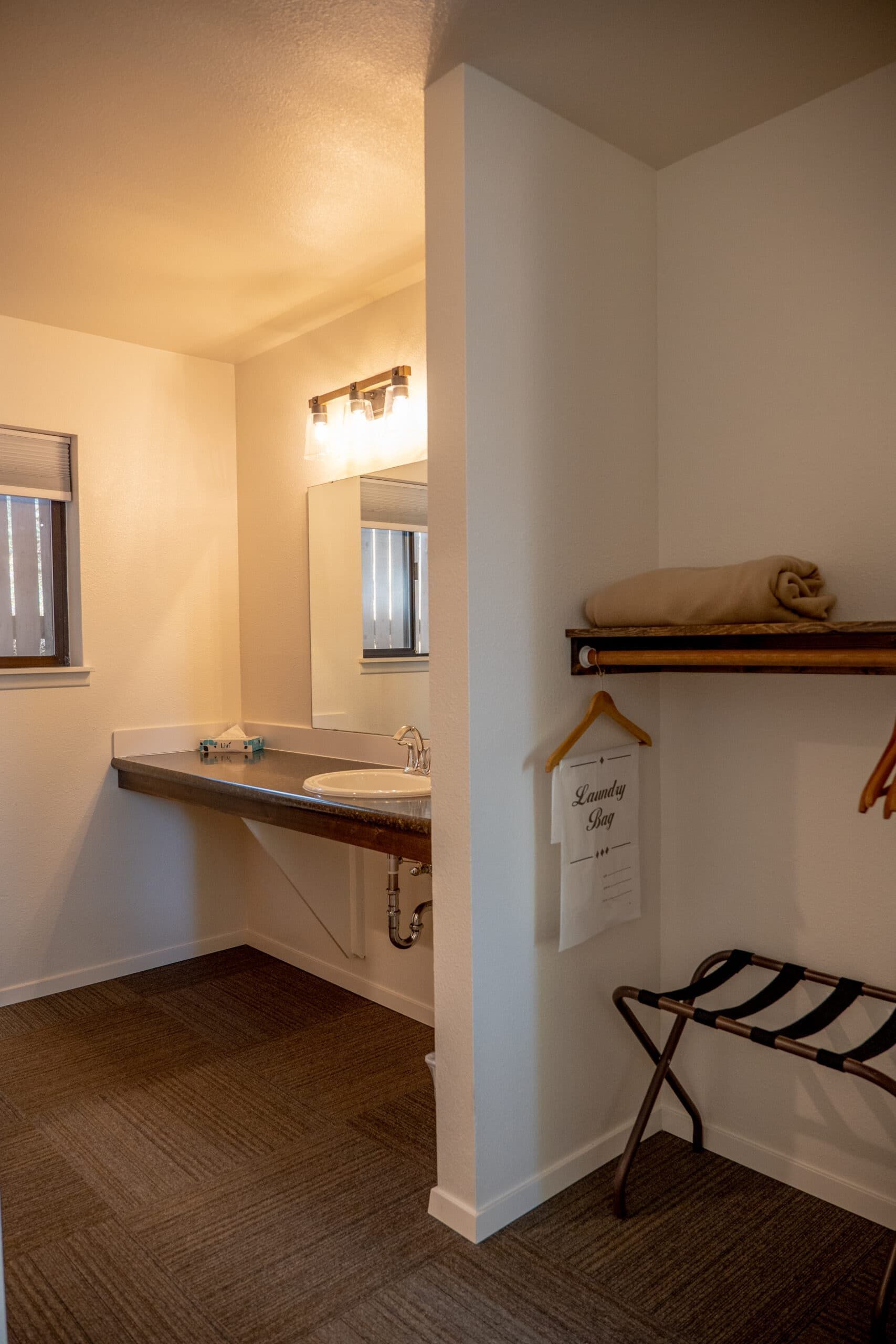A bathroom with two sinks , a mirror and a shelf.