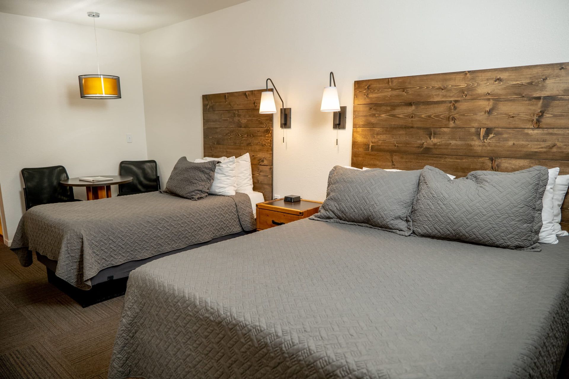 A hotel room with two beds and a chair.