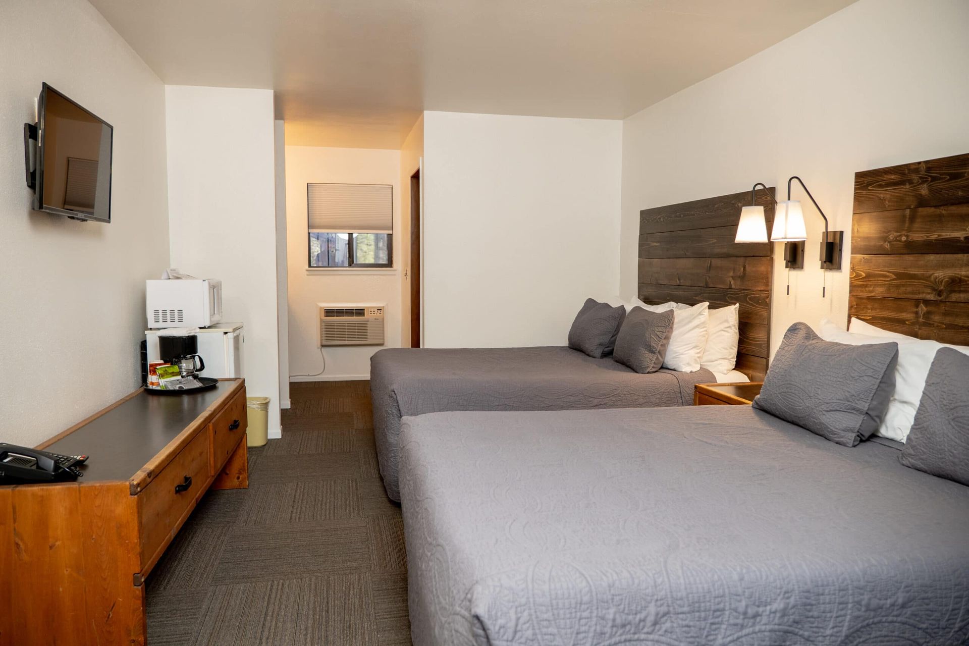 A hotel room with two beds and a flat screen tv.