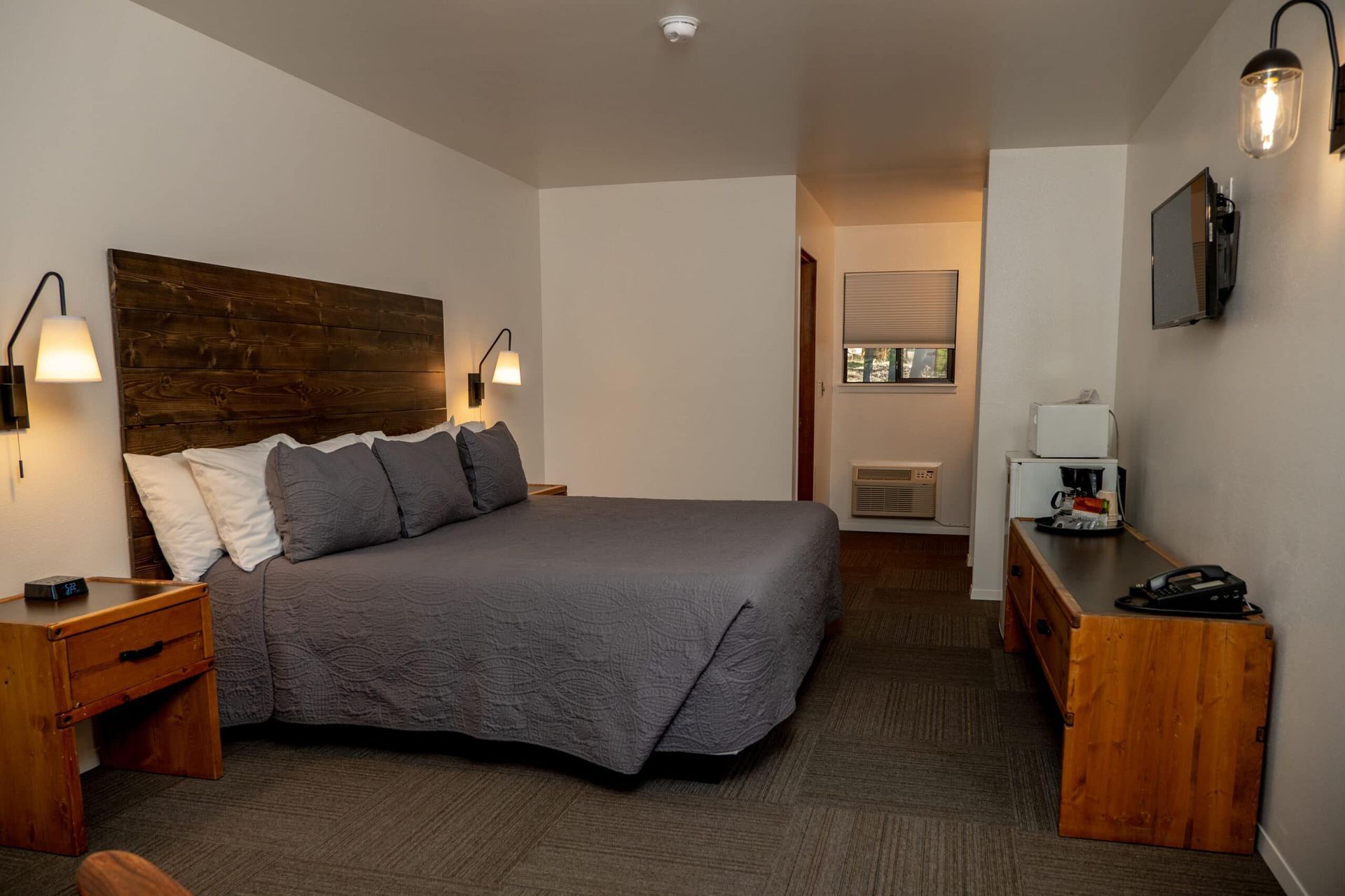 A hotel room with a king size bed and a flat screen tv.