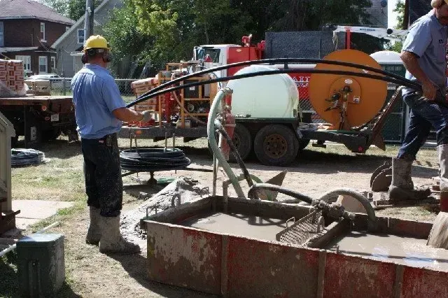 A man in a hard hat is standing next to a tank of water