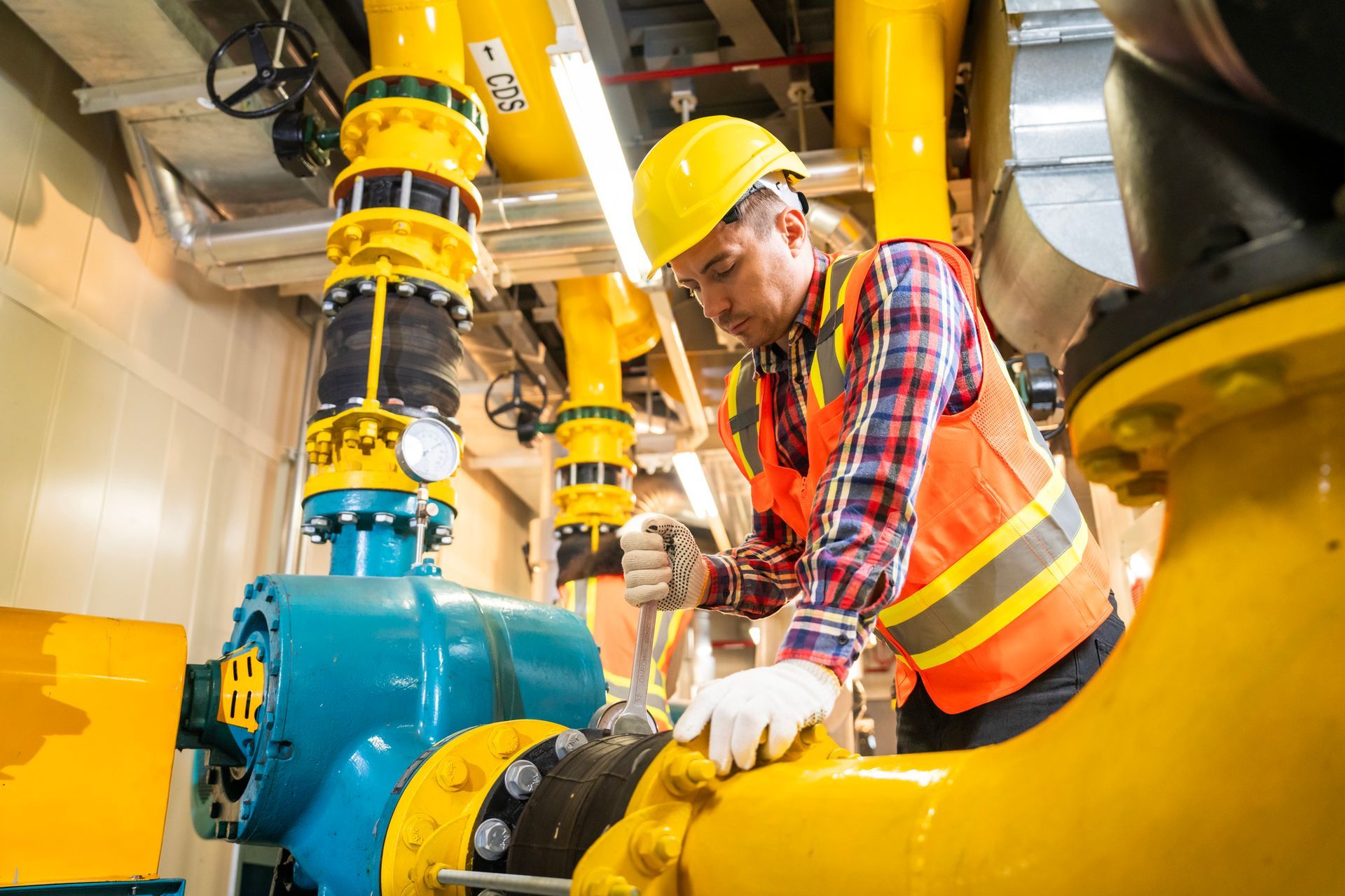 A man is working on a commercial water pump. A man is working on a commercial water pump.