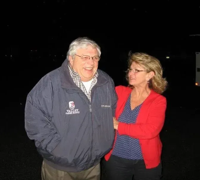 A man wearing a jacket that says columbia is standing next to a woman in a red sweater