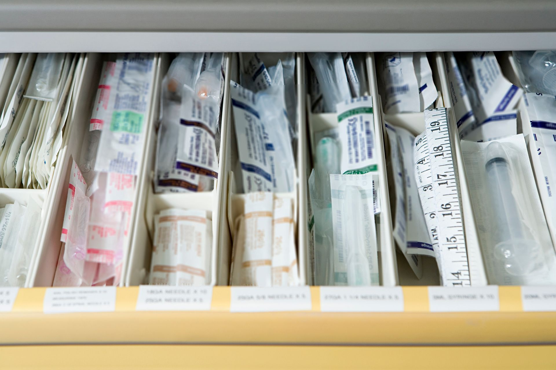Drawer of packaged medical supplies, variety of colors.