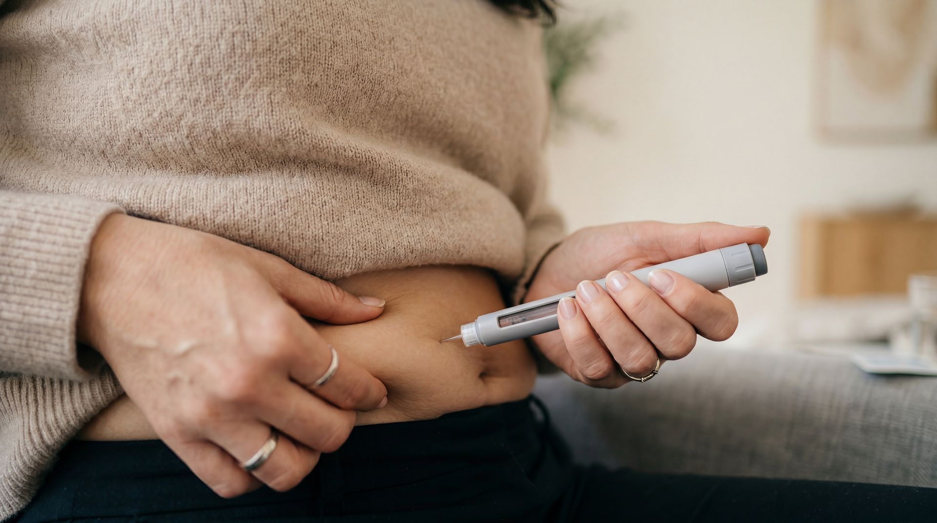 Close-up of a person checking blood sugar with a glucose meter on their belly