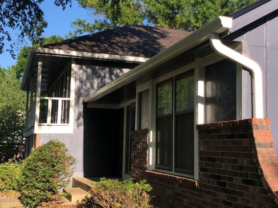 A house with a white gutter on the side of it