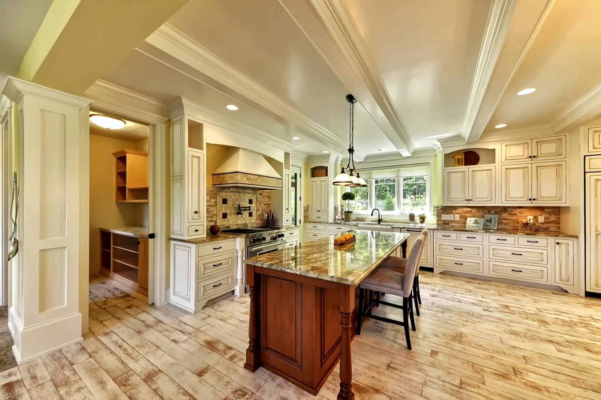 Elegant kitchen with cream cabinets, wooden island, and white ceiling beams.