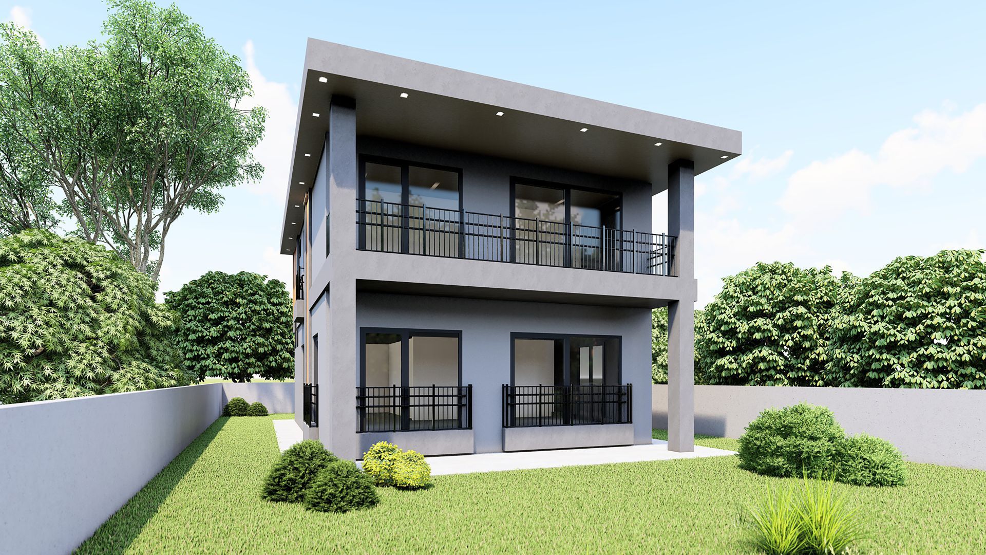 Two-story gray house with balconies and black railings, set on a grassy lawn with a white wall and shrubs.