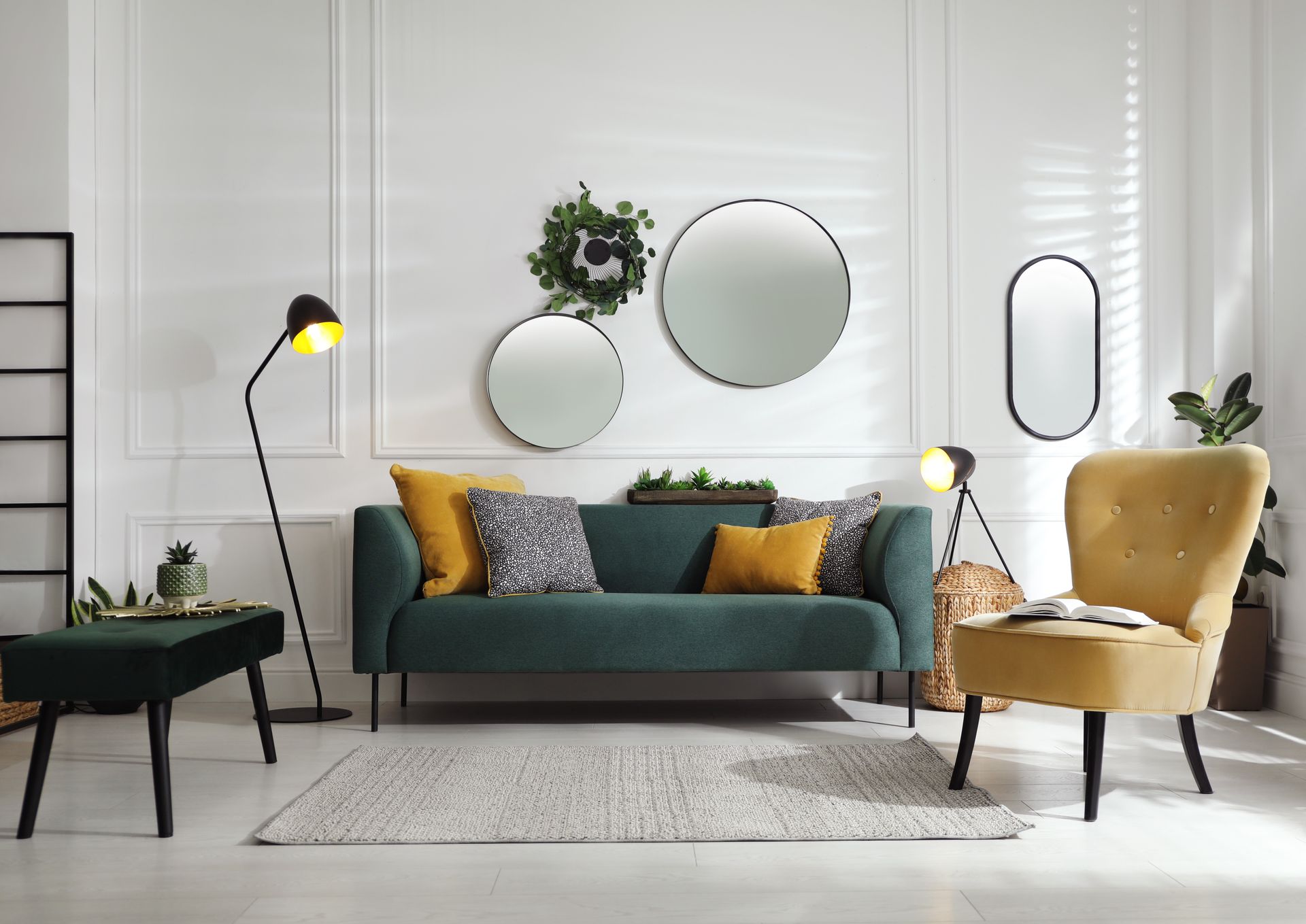 Living room with teal sofa, yellow chair, mirrors, and lamps against white walls.