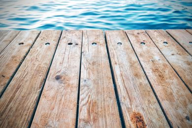 Wooden dock extending towards blue water.