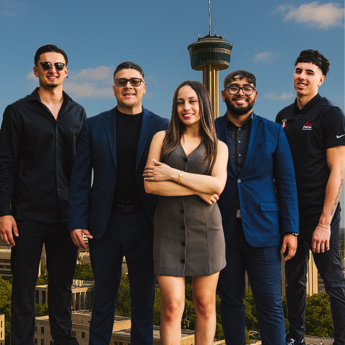 A group of people posing for a picture with a tower in the background